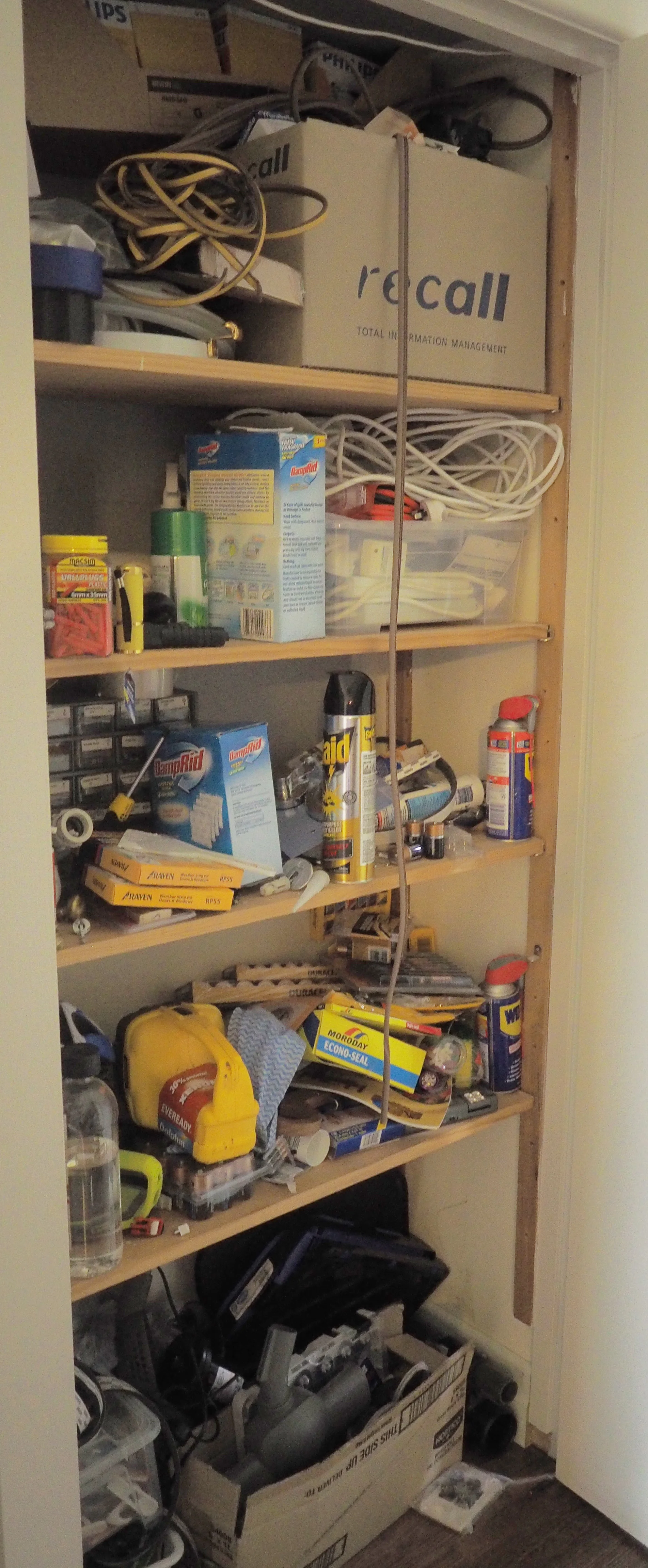Cupboard disorganised before makeover