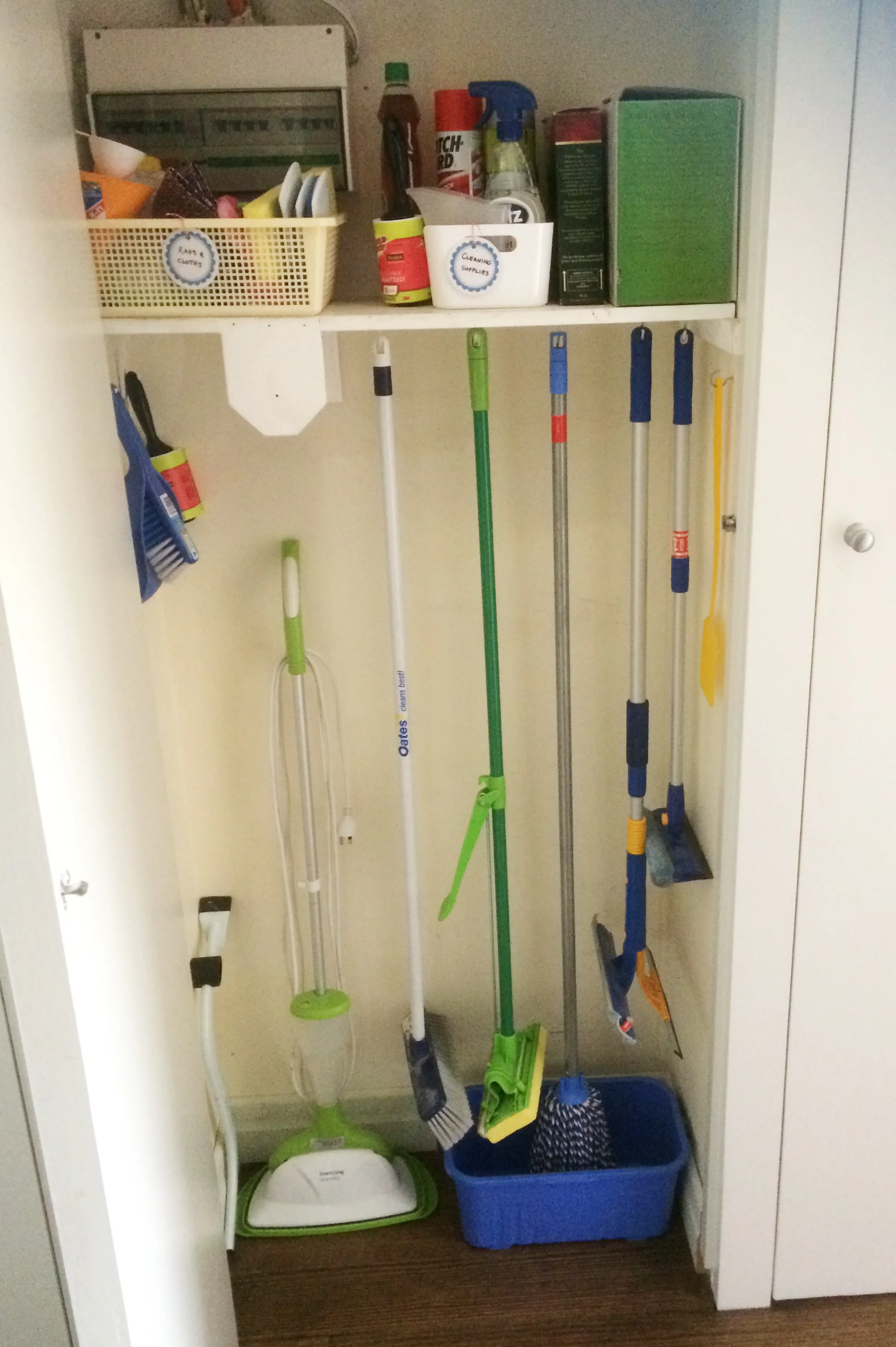Hanging mops and brooms from hooks in a cupboard allows them to be easily accessible and prevent them from sliding around inside the cupboard