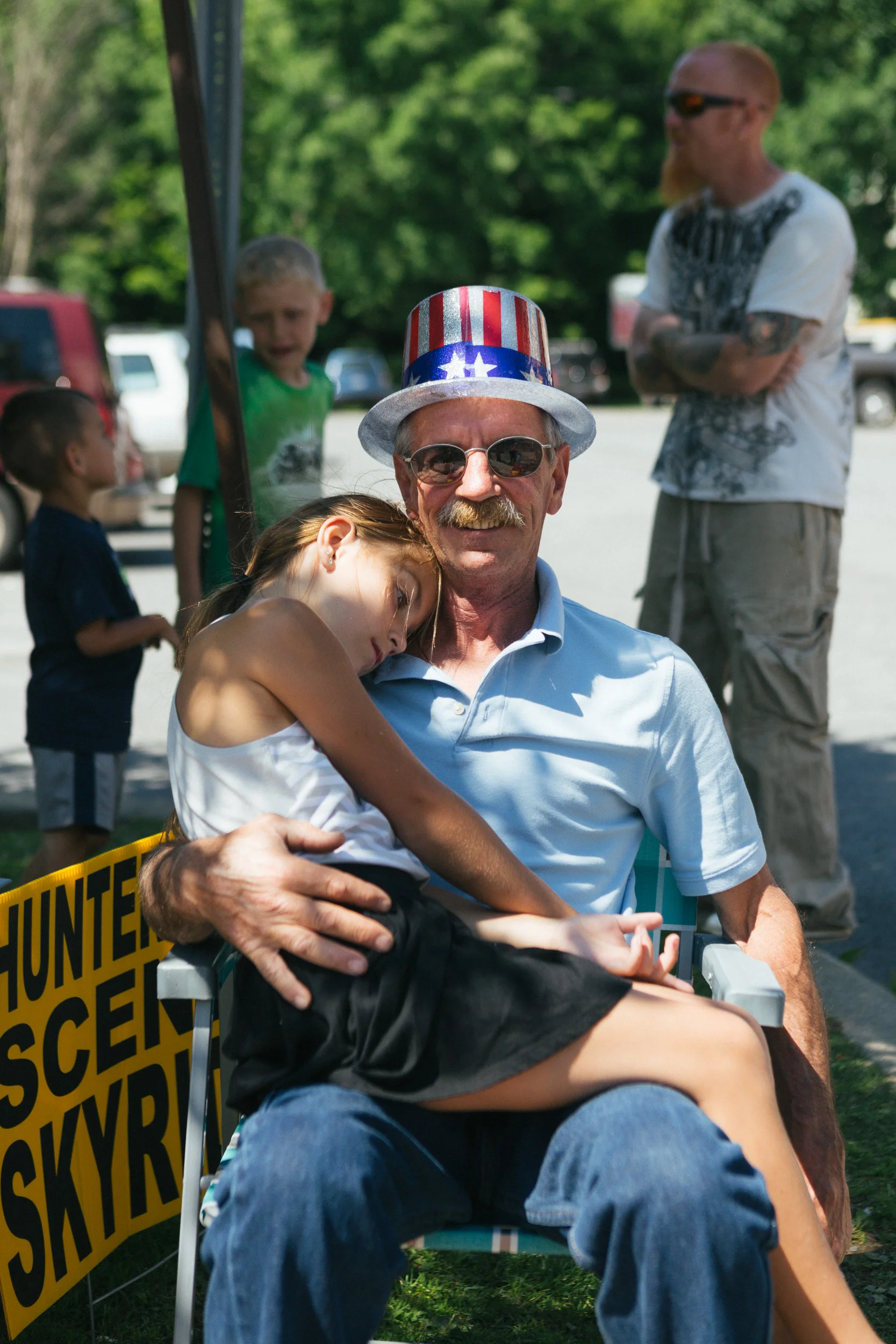 A man holds his granddaughter as they wait for the parade to begin.jpg