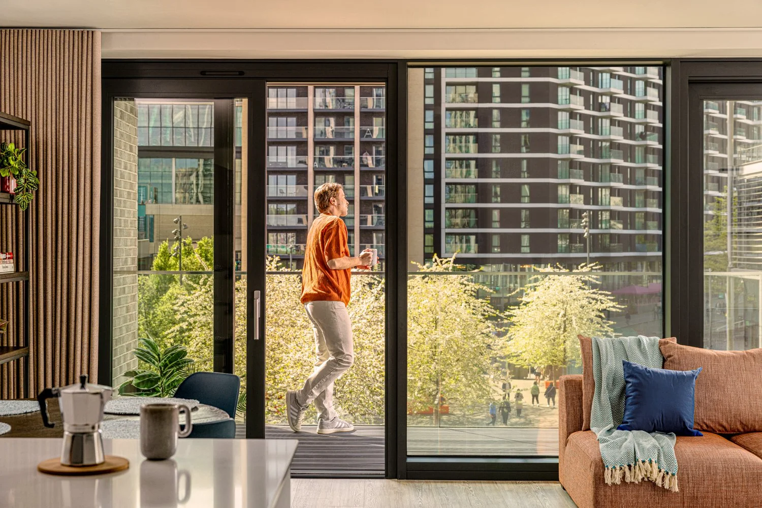 Man enjoys a coffee on his balcony in the sun 