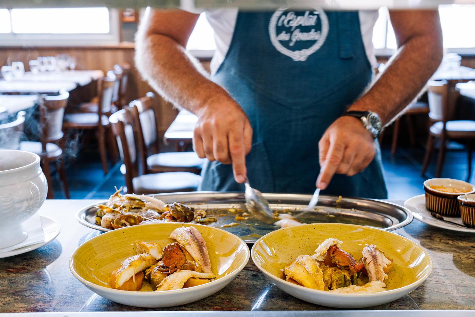  Bouillabaisse: CCutting the cooked fish and serving in into bowls with the fish soup at L'Esplai du Grand Bar des Goudes.  Photo by hospitality and restaurant photographer Clara Tuma 