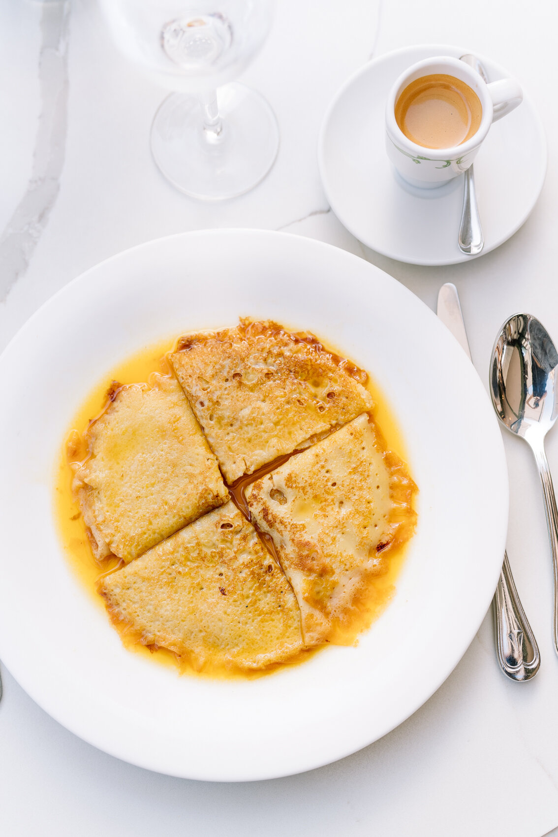  The original Crêpe Suzette served with an espresso and water on a white-marbled table at Café de Paris in Monaco. 