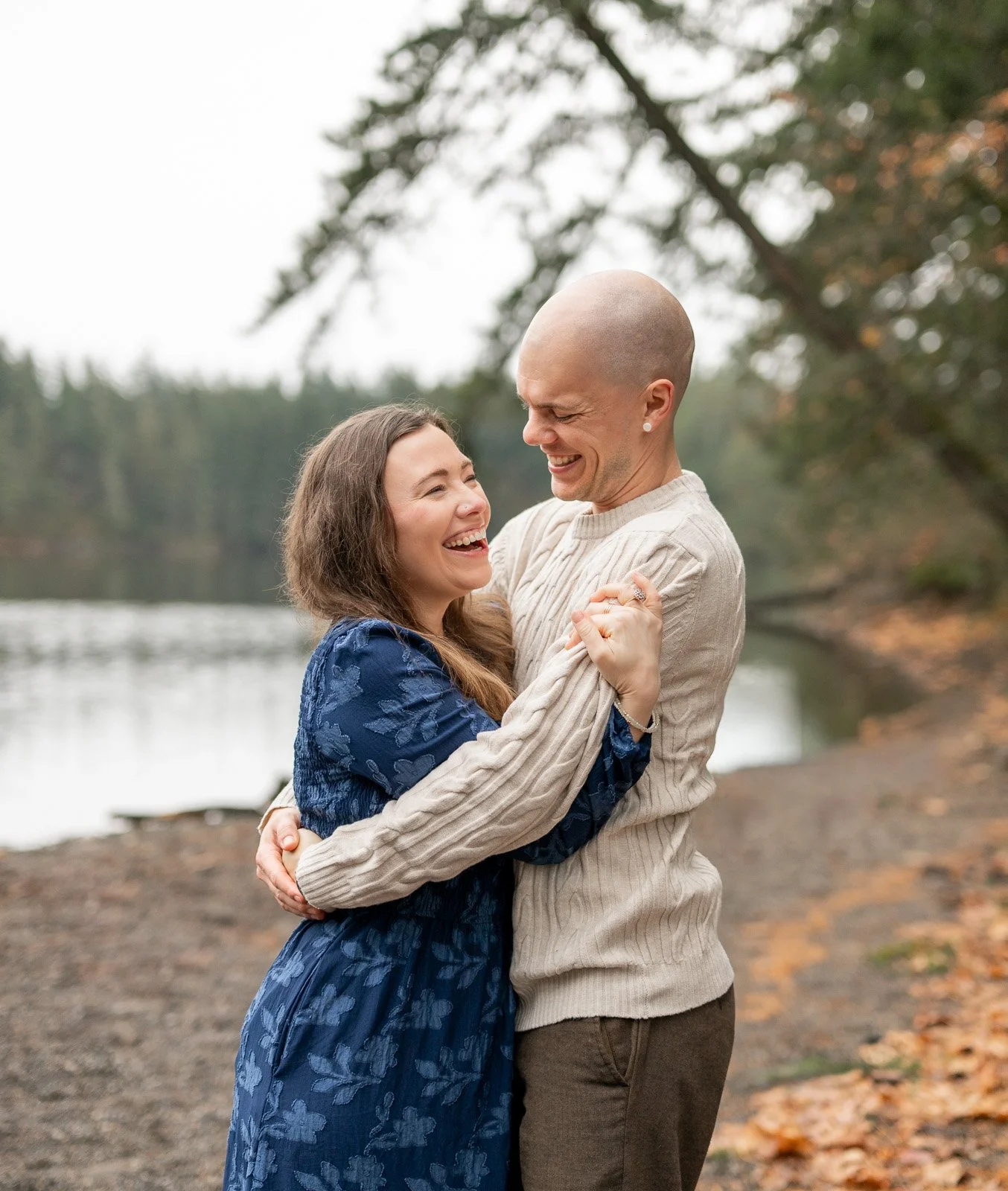 Parents laughing together by the lake during a relaxed outdoor family photography session in Olympia, WA.