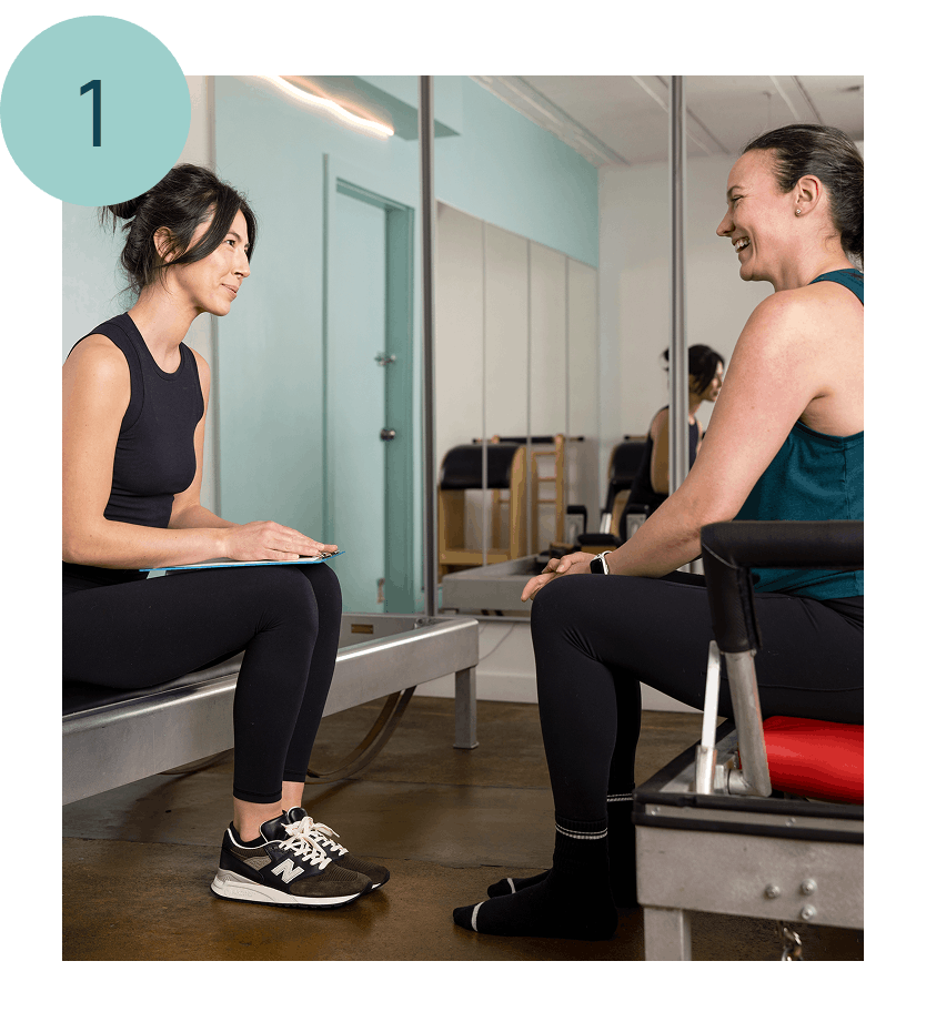 two women sitting on reformers in a pilates for postpartum class in seattle at union pilates