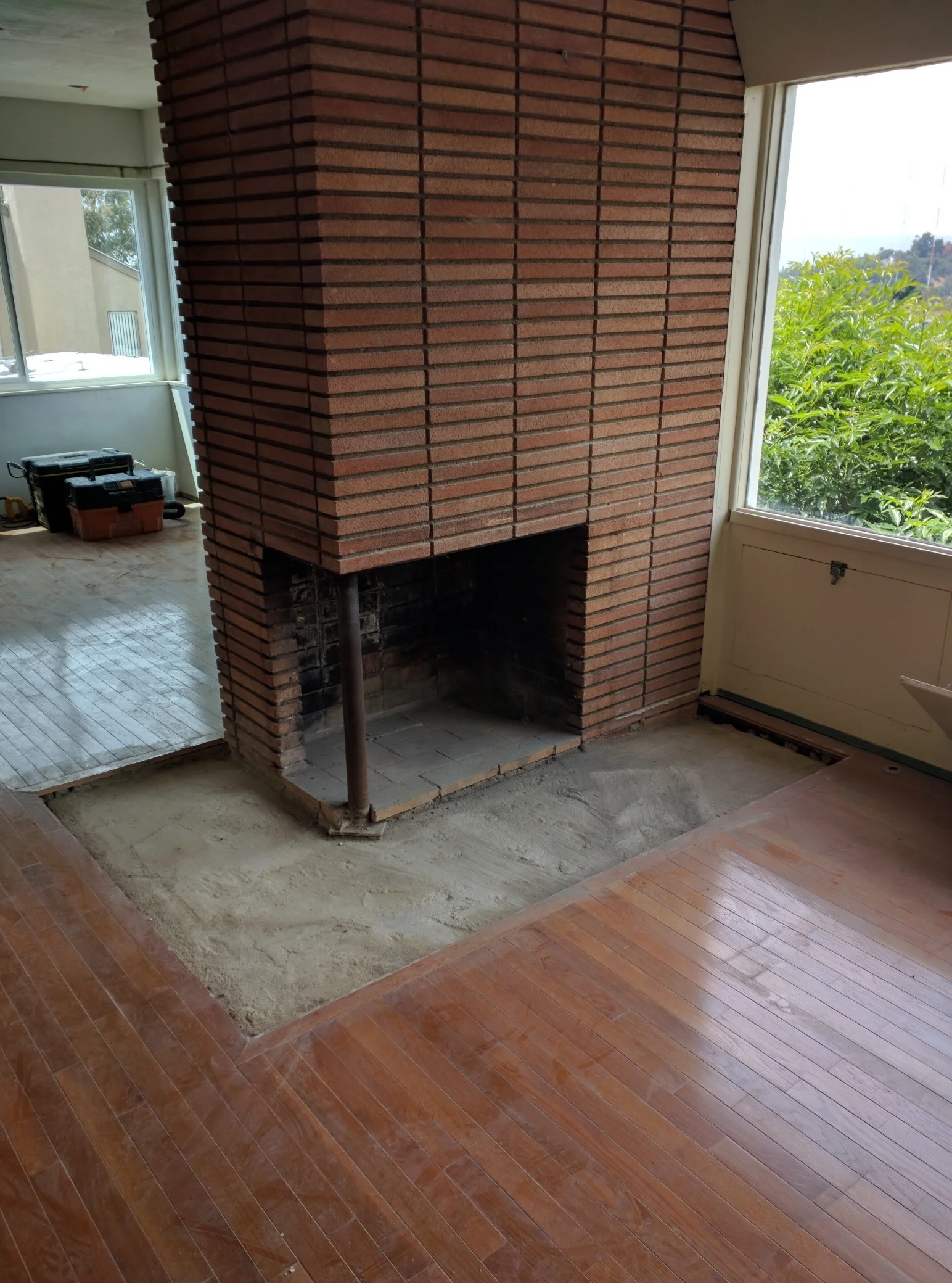  The brass fireplace enclosure has been removed showing the original open fireplace, quite nice. We will clean up the bricks, replace the broken ones and repaint the interior and post a dark, flat black. 