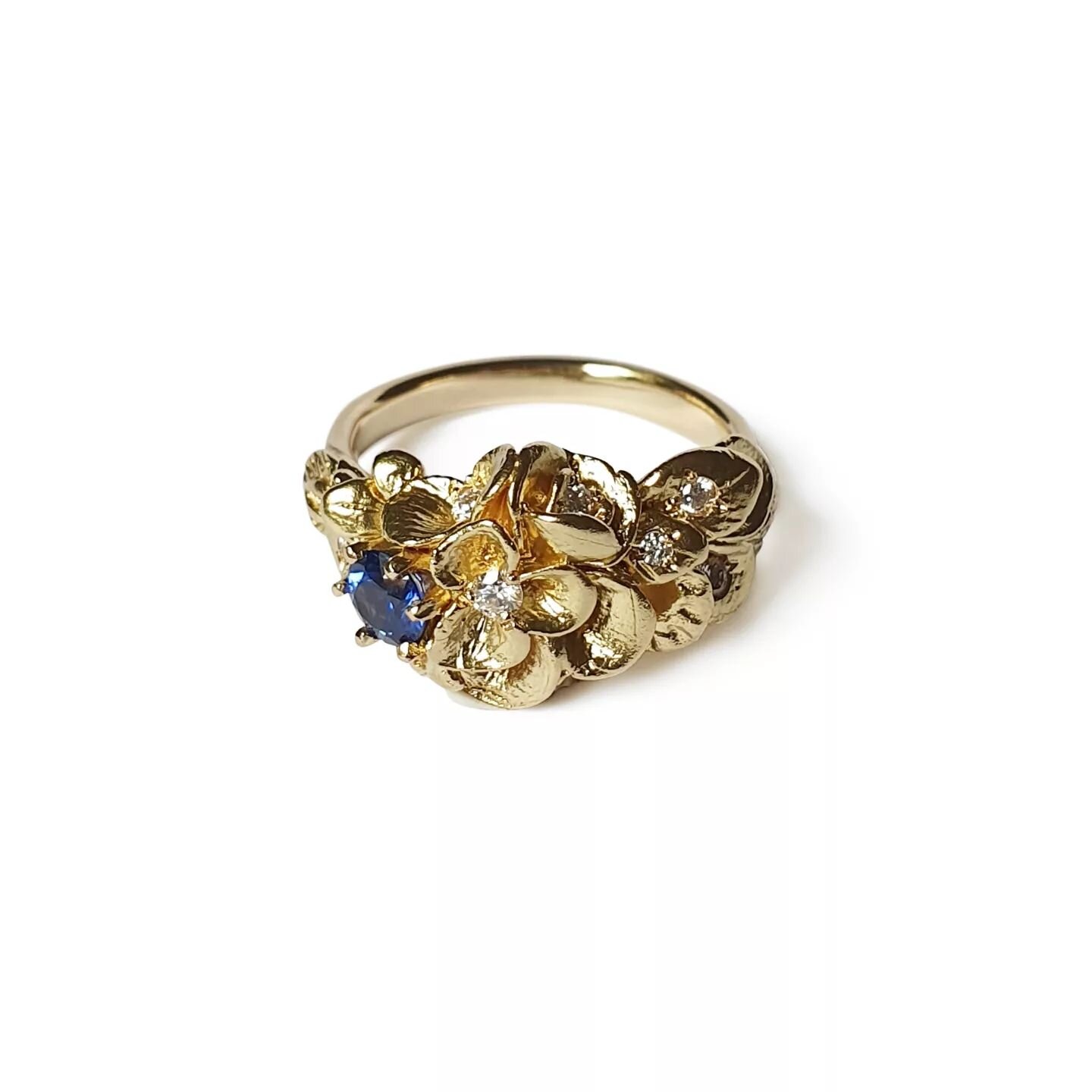 Hello friends💎

This is one of the first floral ring designs I made. It is still a favourite. 

This incarnation is in 18ct yellow gold,
with a striking ceylon sapphire and white diamonds set into the petals and leaves.

Fit for a queen don't you th