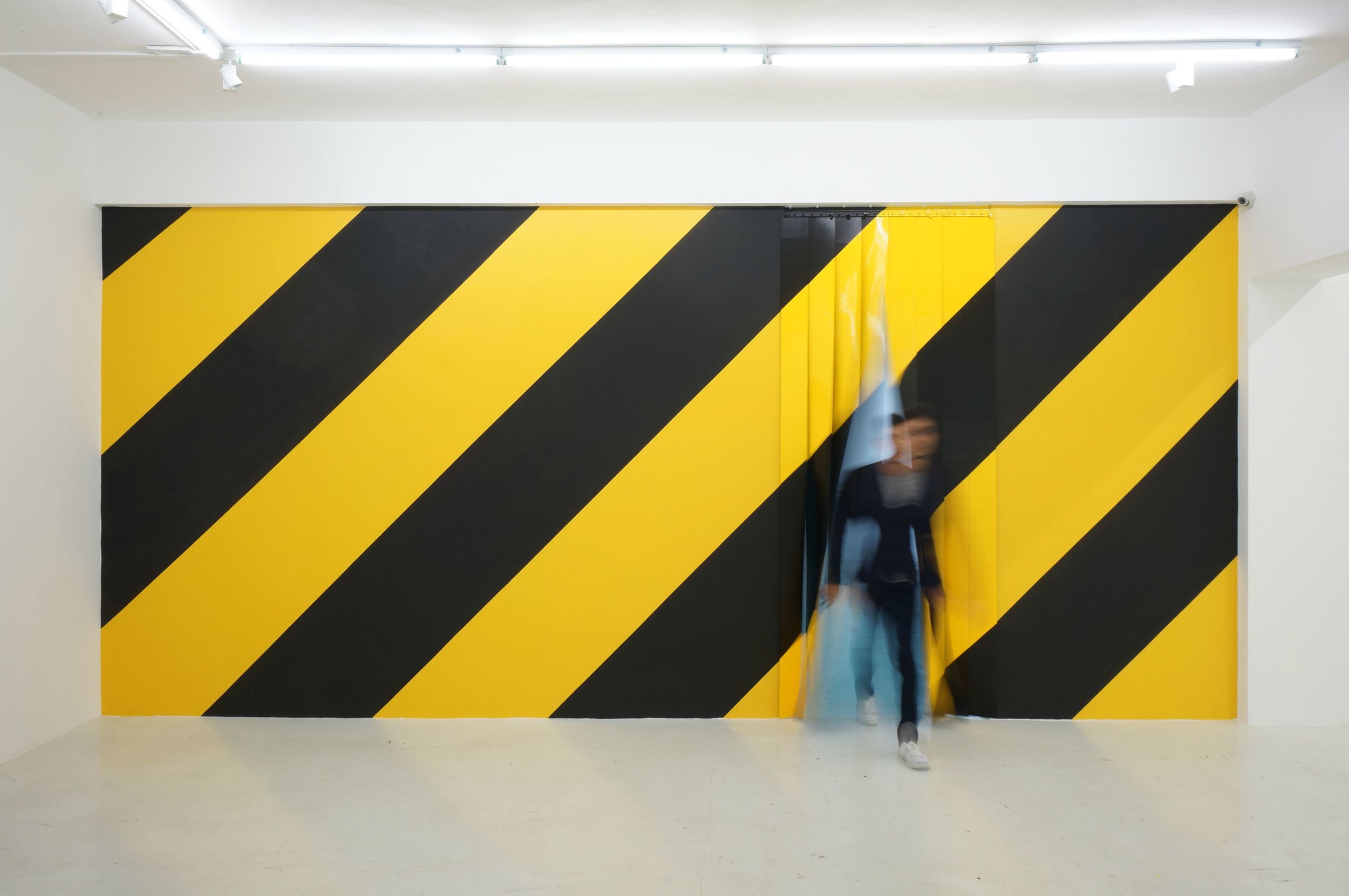 Michael Lee, Diagonals (installation view with the artist), 2014. Emulsion on wall, polyurethane on PVC and enamel on galvanised iron, 294 x 650 cm. Yavuz Fine Art, Singapore. Photo by Ken Cheong.