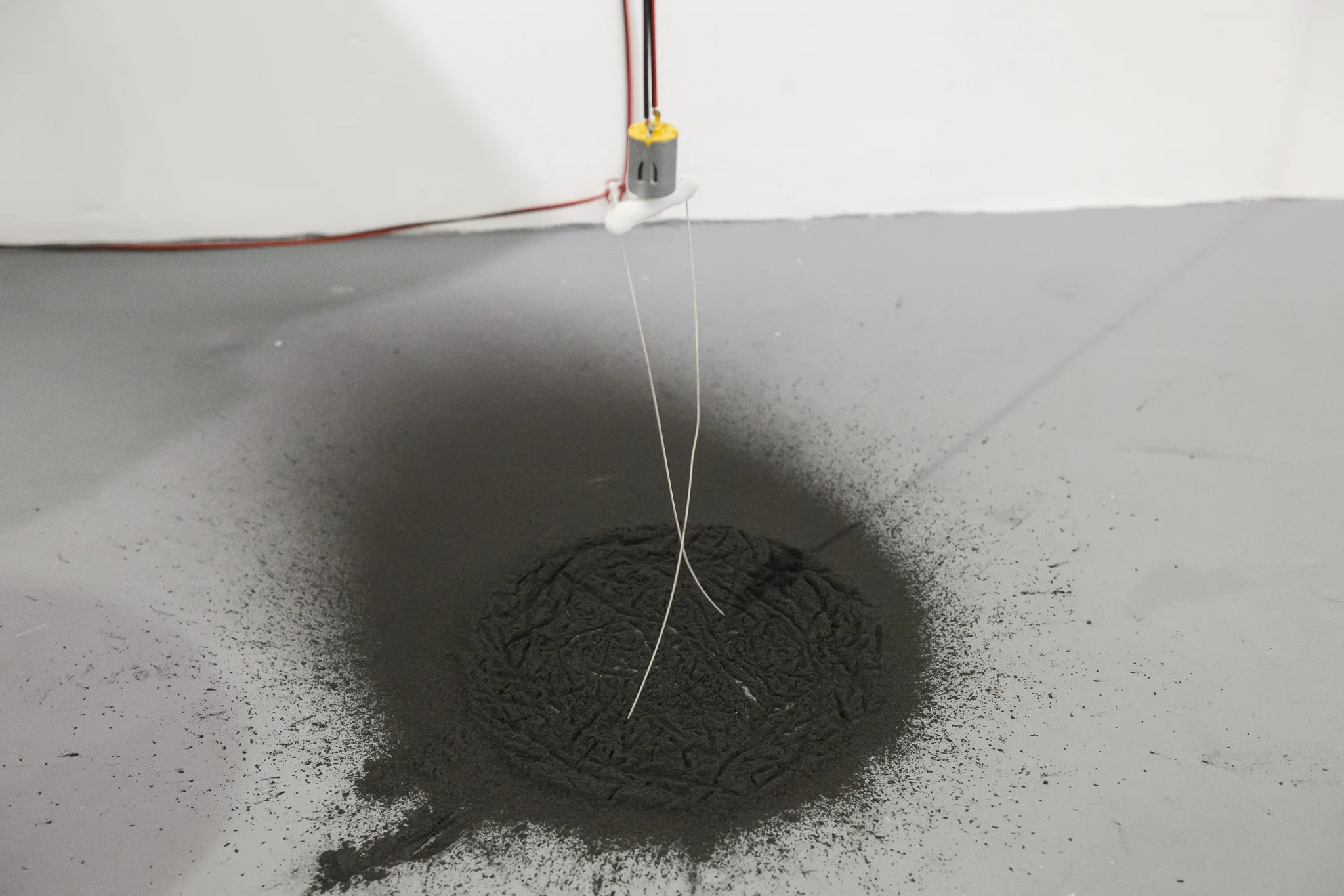 Huijun Lu, Crumb, 2018, Graphite powder, polymorph, rotating motor, instrument strings, Arduino Uno