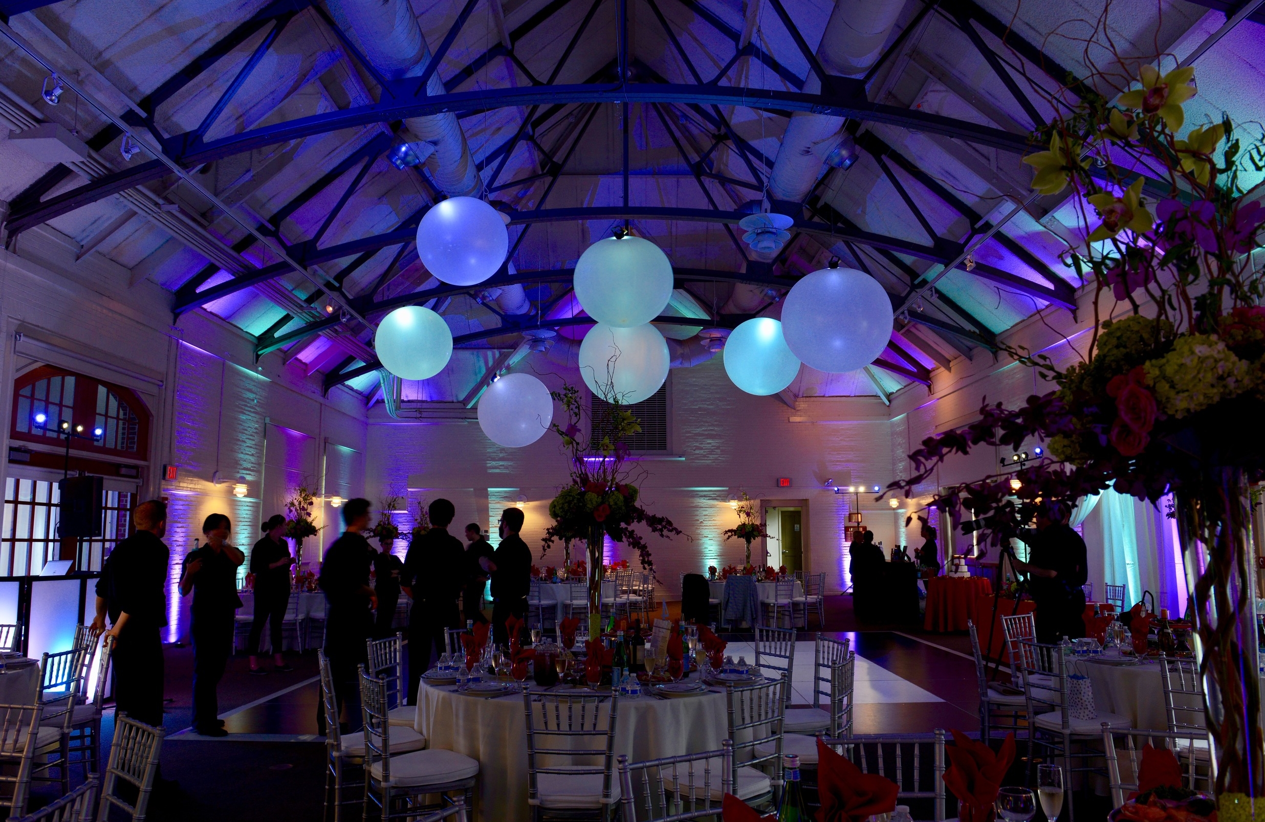 The guests entered a room of teal and purple. Warm light around the room was kept at the level of the tables to illuminate them separately but not brightly so as not to lose the effect of the colored light.