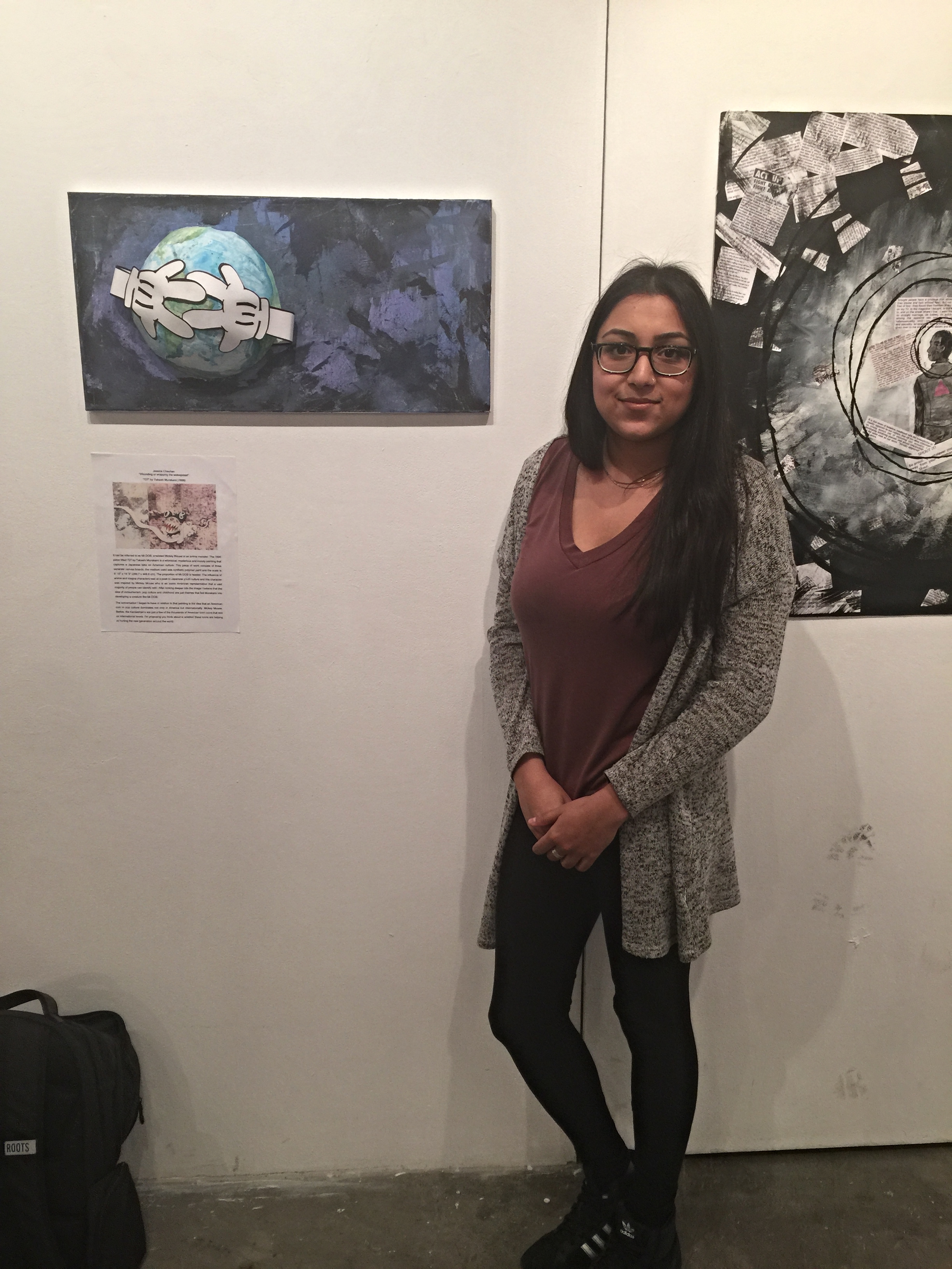 Jessica standing with the art work she exhibited at KPU as part of the "Talking Back" exhibition ahead of the trip portion of the field school.
