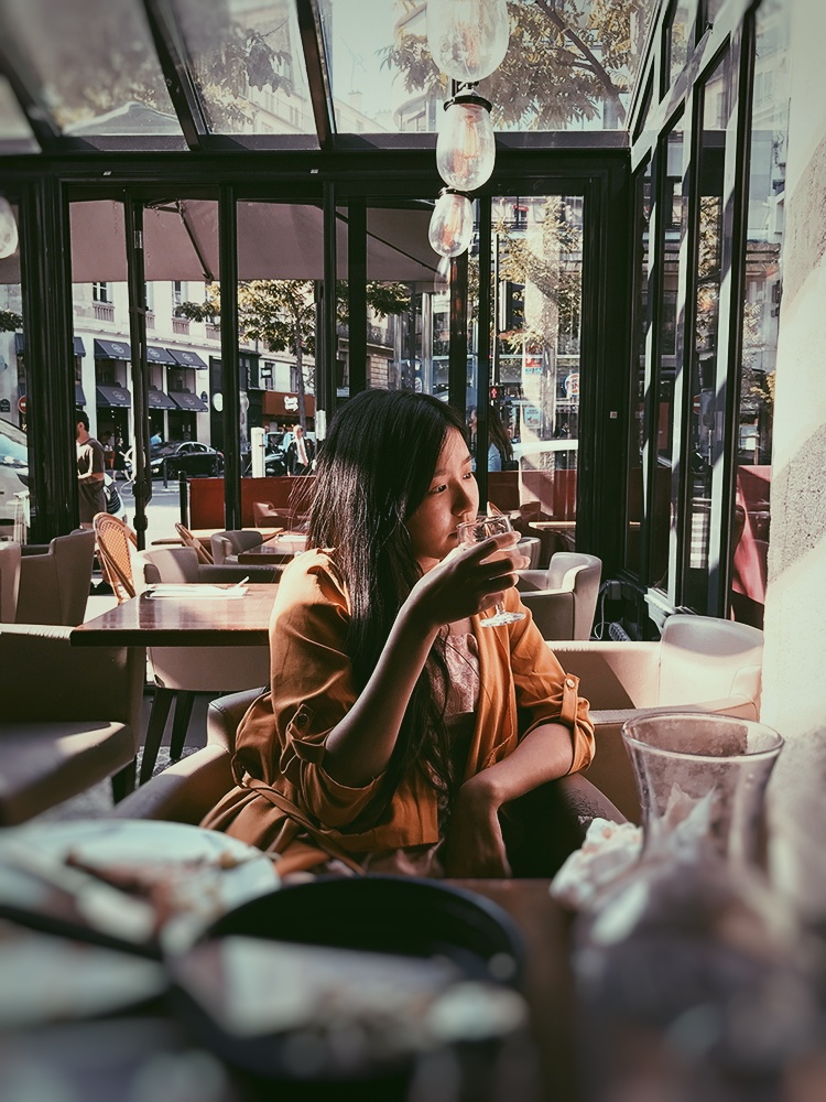 Tiffany taking the time to enjoy the moment in a Parisian café.