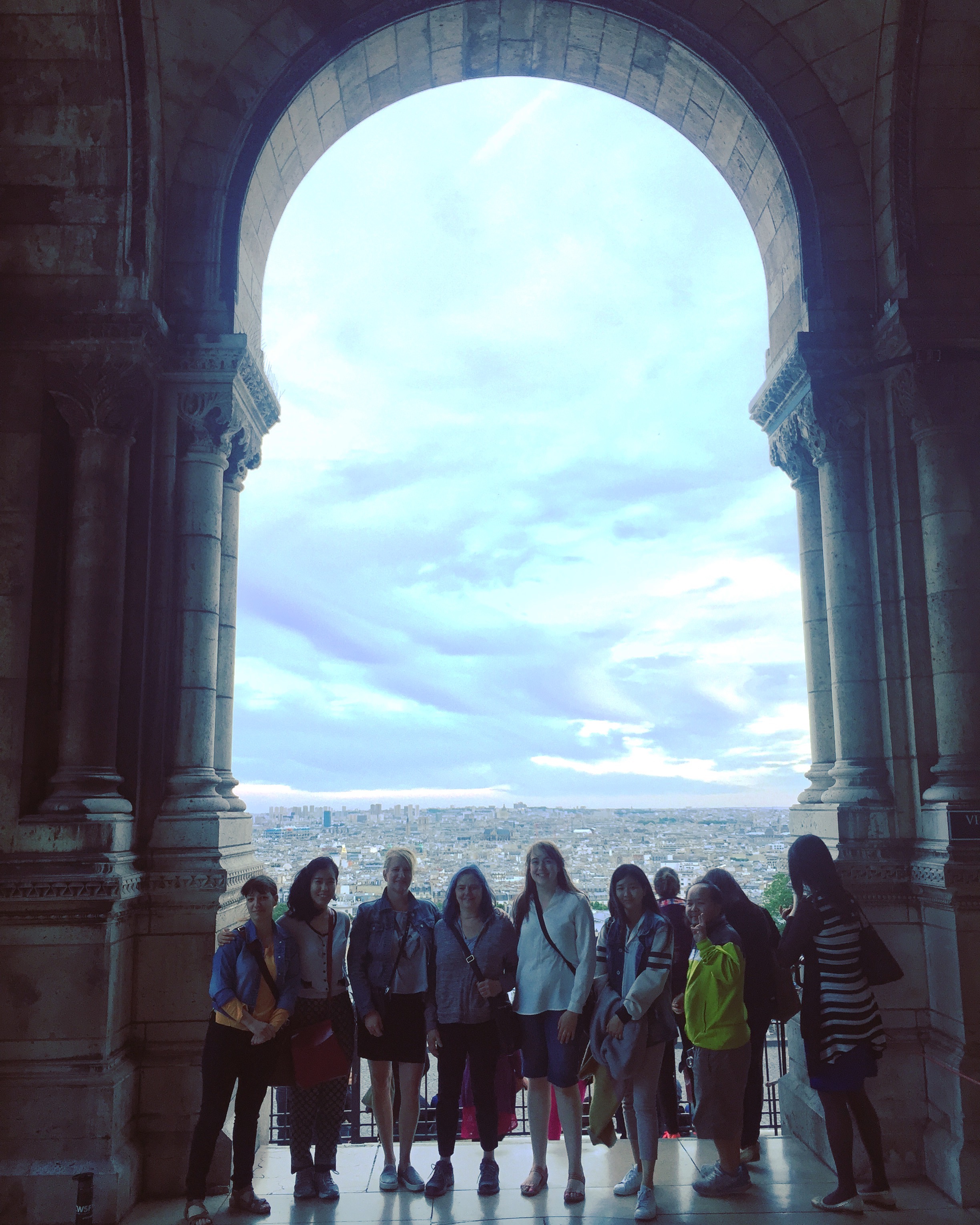 Group picture overlooking the city at sunset from the Sacre Coeur Basilica portico in Montmartre-- Josie at center. 