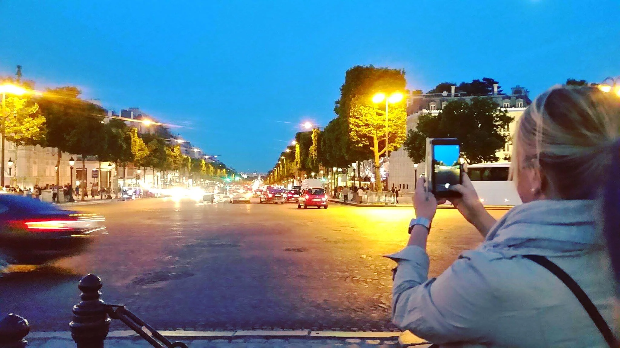 Dorothy photographing the Champs-Élysées after touring the Arc de Triomphe.