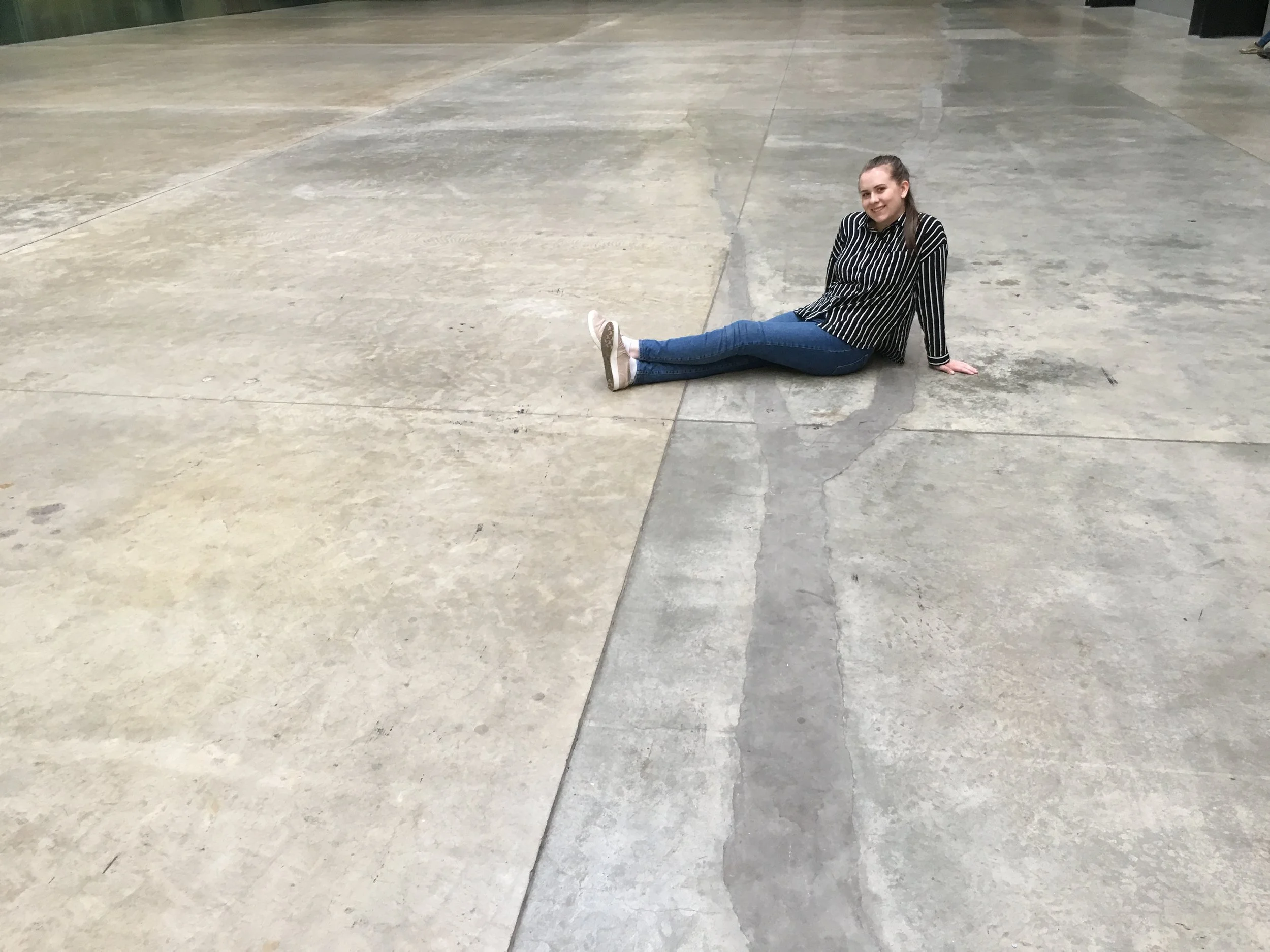 Alison pictured in the Tate Modern’s Turbine Hall sitting on the scar left behind by Doris Salcedo’s large scale project Shibboleth II (2007).
