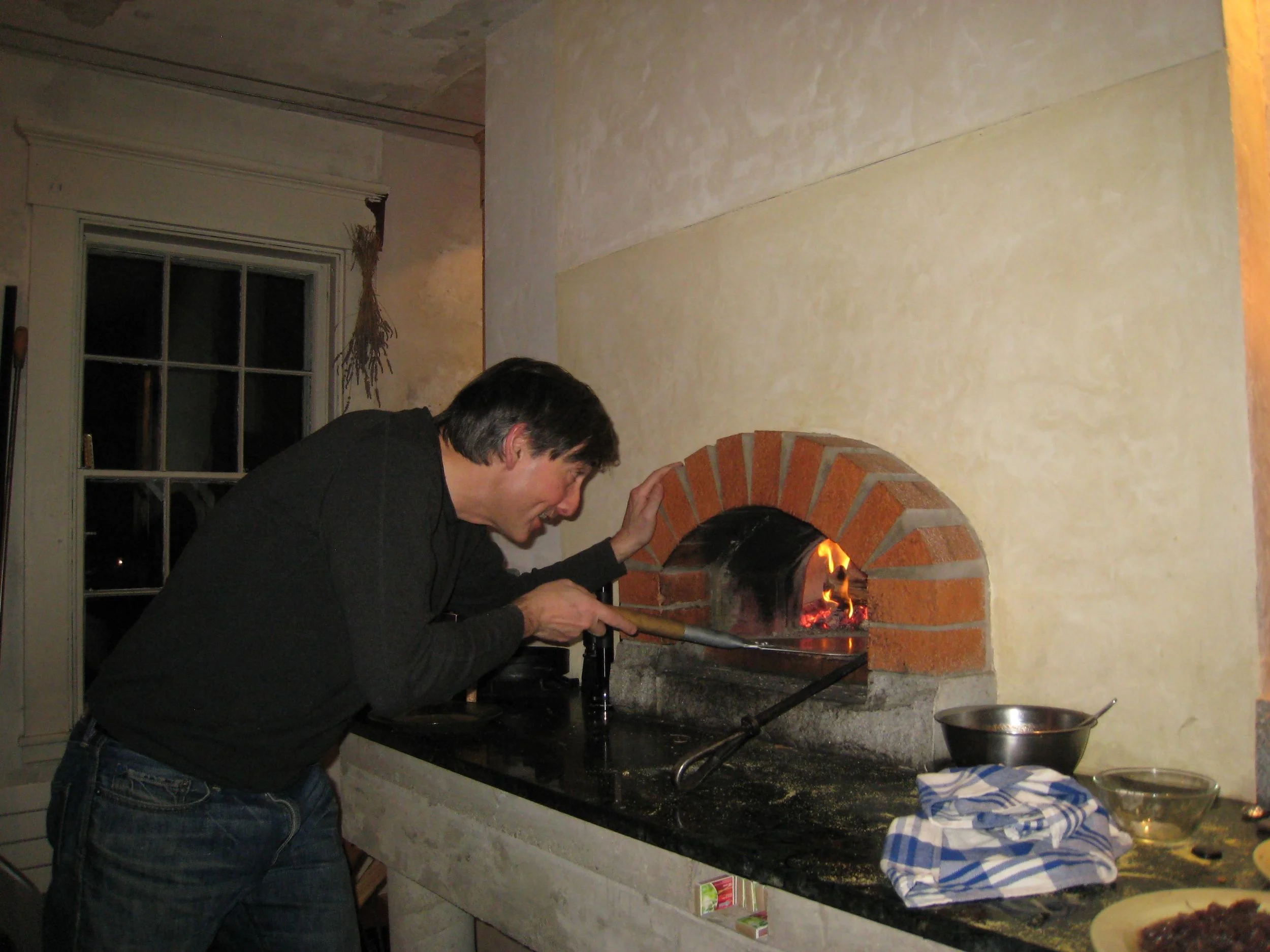 stoking the fire in the pizza oven