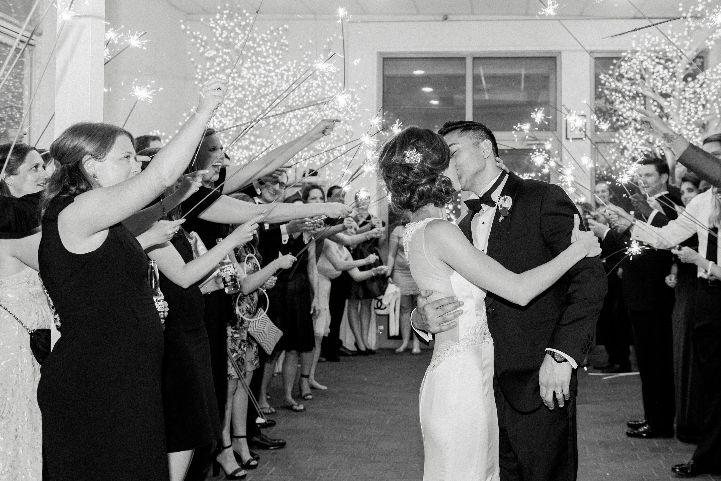 Bride and Groom kissing while the guests form the Sparkler exist at the Battery gardens wedding in Manhattan.