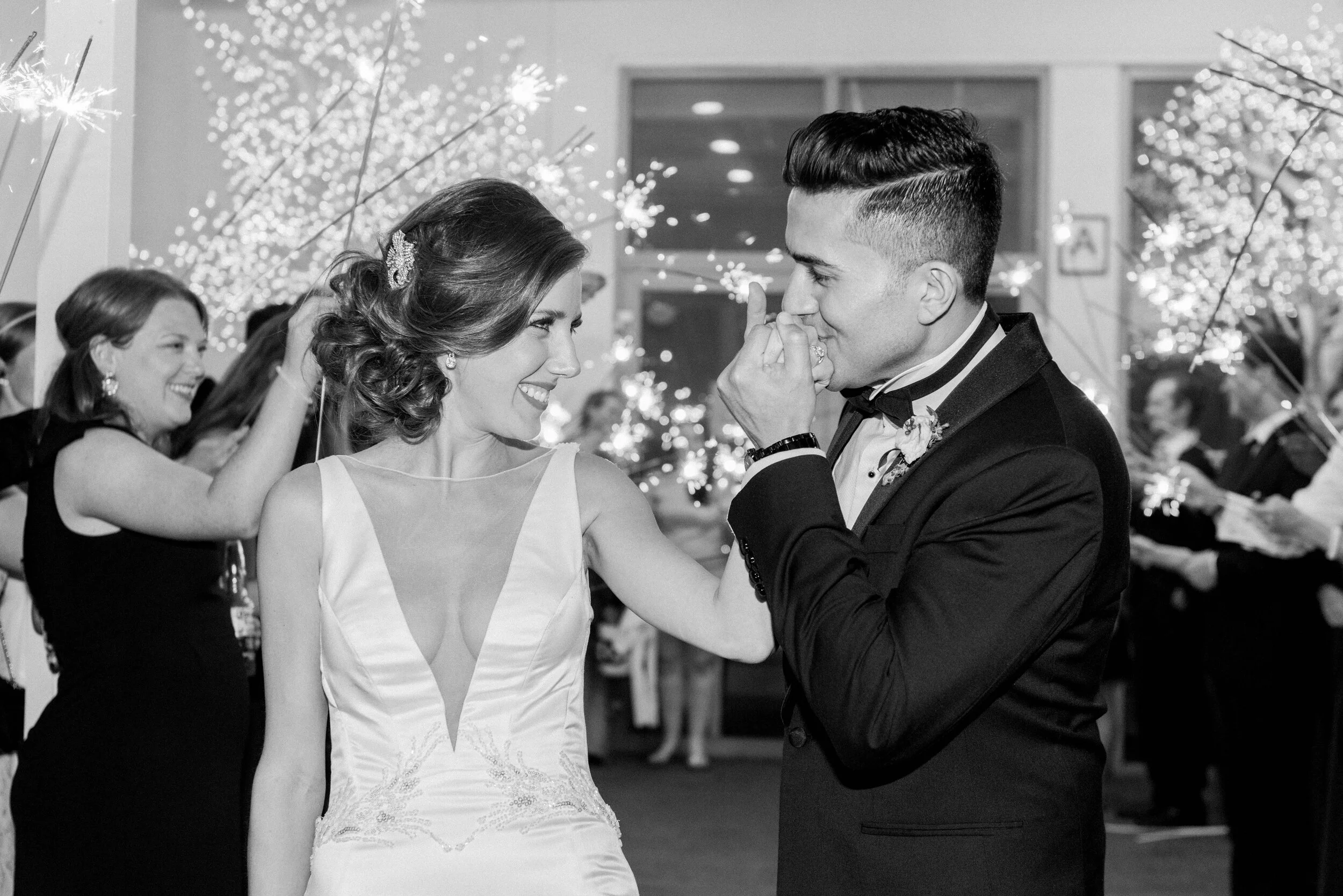 Stunning Manhattan Bride and Groom looking at each other while they walk out the Sparkler Exit of their Manhattan Wedding Day at Battery Gardens.