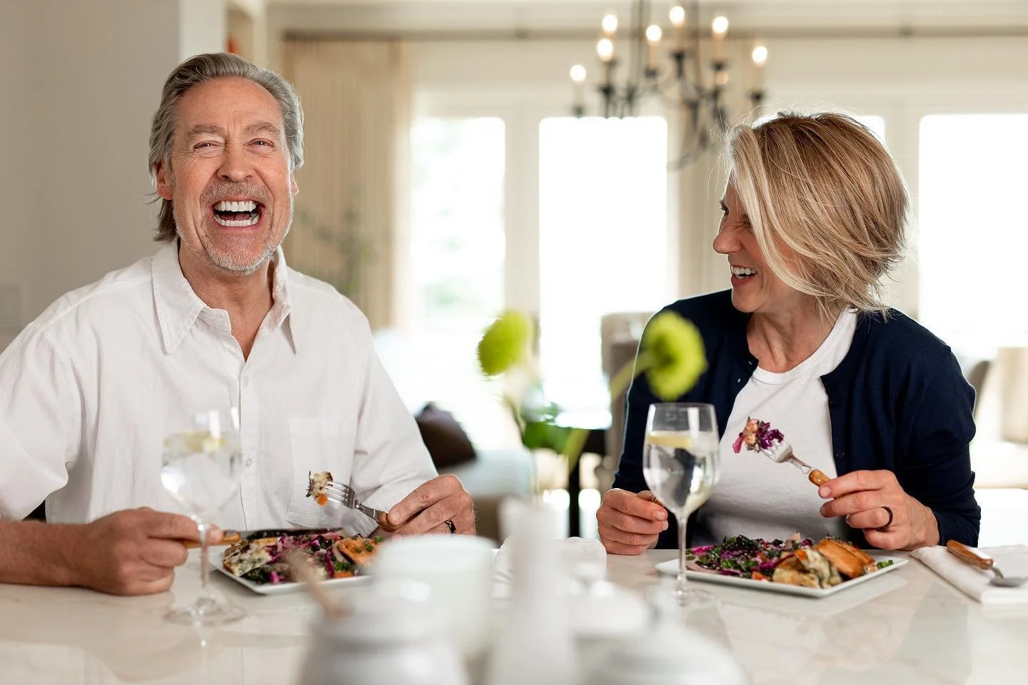 A couple enjoying a meal together, laughing