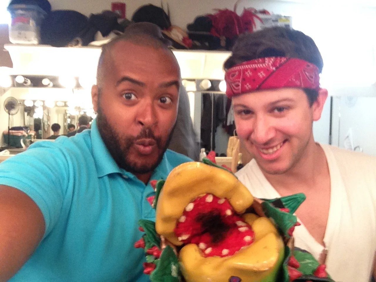 Alex Agard (Voice of Audrey II) and Joe Longthorne (Audrey II puppeteer) pose with one of the Audrey II puppets backstage.