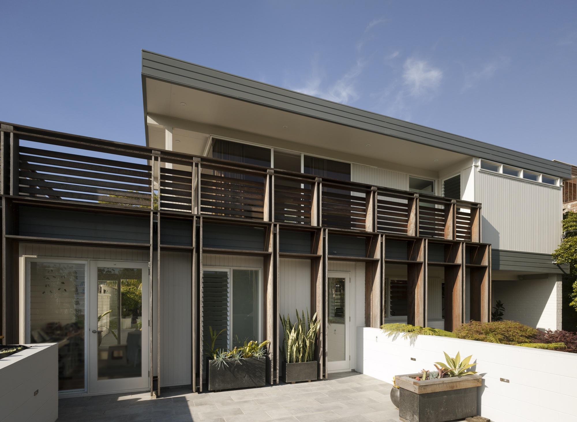 A sculptural timber screen is used to create a strong presence whilst also creating privacy for the interior . The facade colours create an identity on the street. The screen integrates the expanded floor within the street façade, emphasizing the horizontal element of the façade, adding depth to the façade, and filtering views from the street.