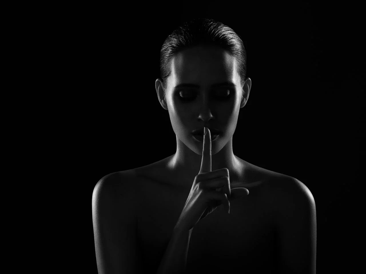 model with finger to lips in shhh pose