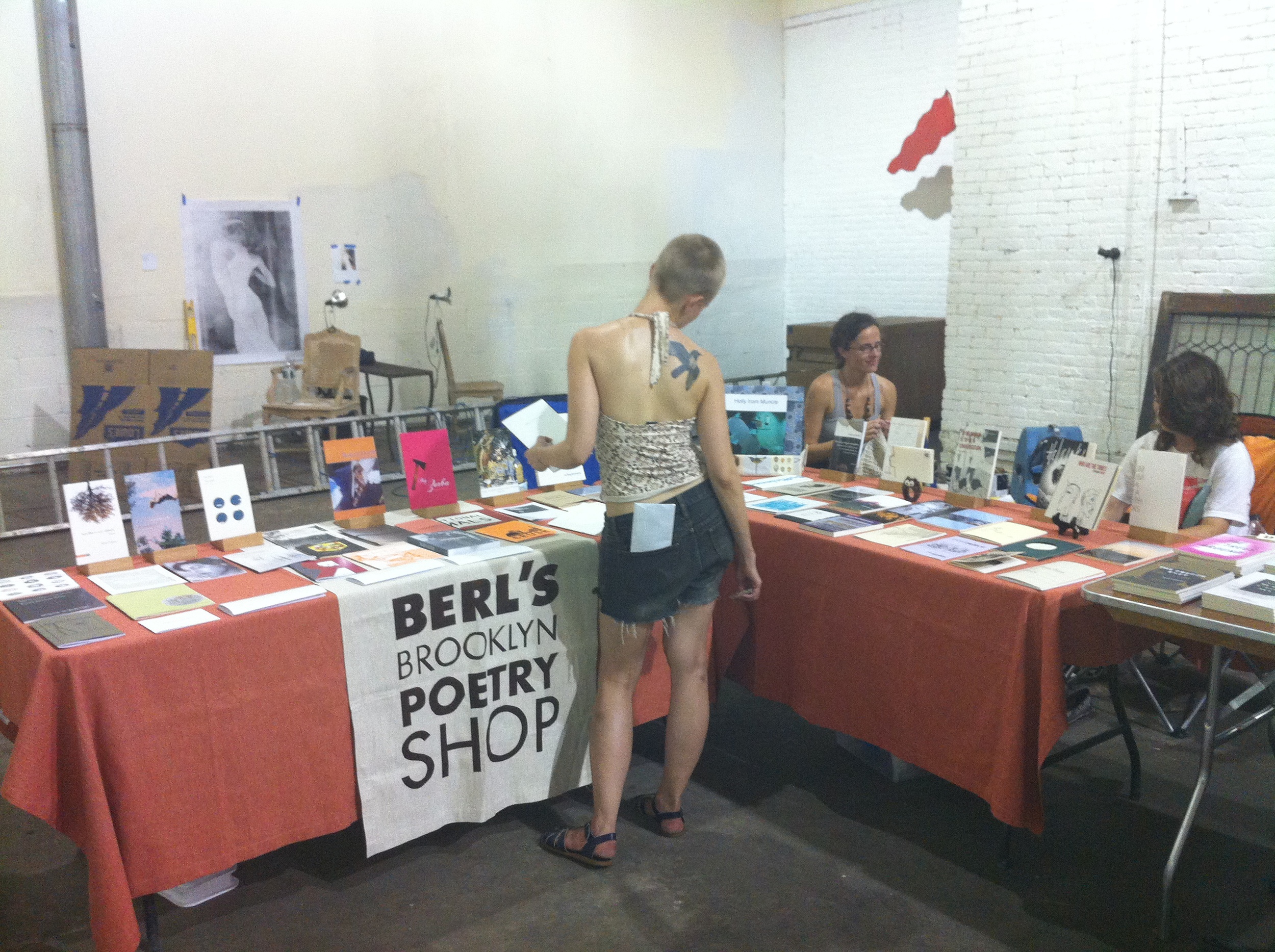  Popsickle Poetry Festival founder Niina Pollari peruses books at Berl's pop-up booth, including MY ZORBA by Danielle Pafunda (Bloof Books). 