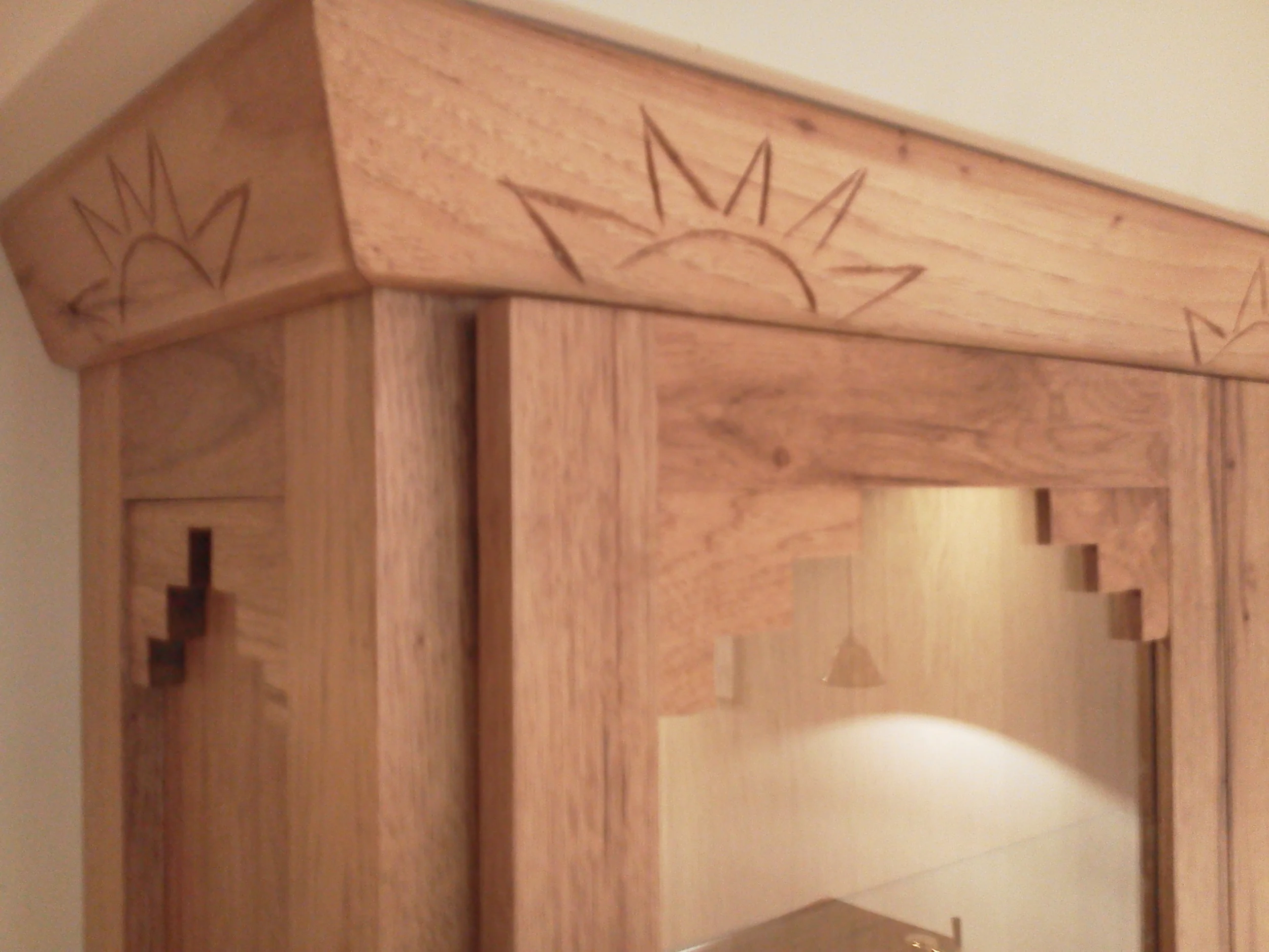 Carved crown and stepped detail on doors and side panel.