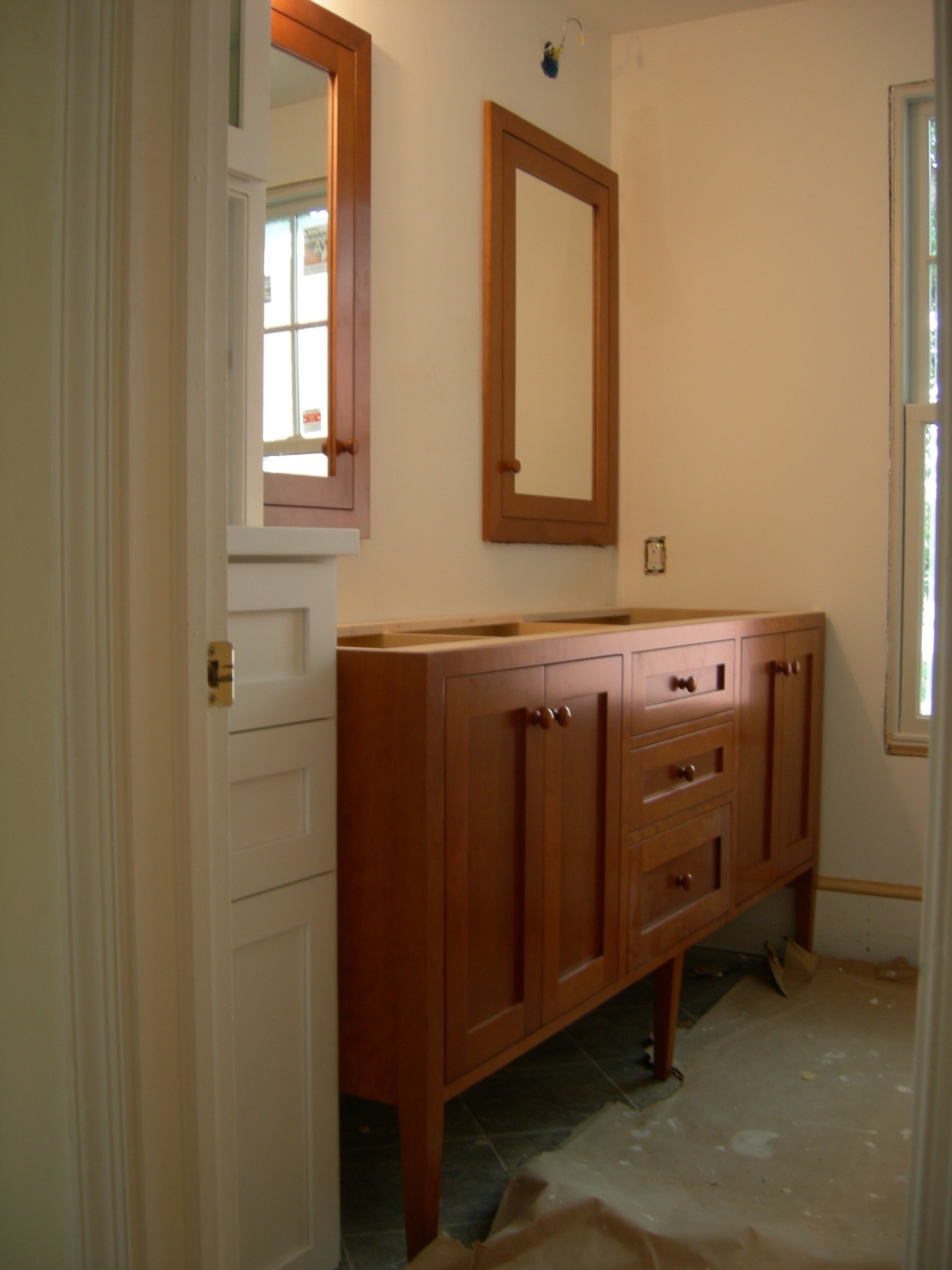 Cherry vanity and medicine chests and painted cabinets just in view.