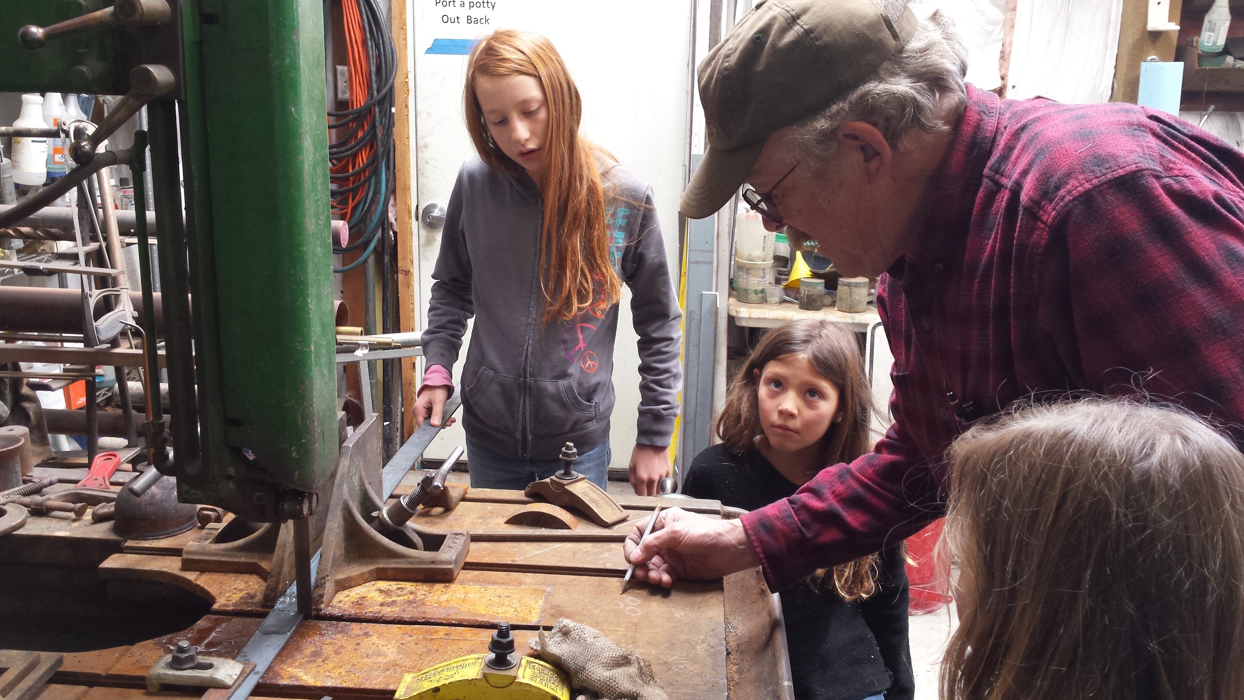 The girls learning about measuring and cutting steel.