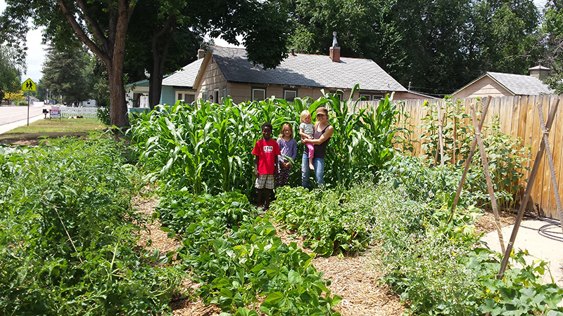 Lynn with her three kids, Kevin, Reese and Harper in front of the thriving corn!. 