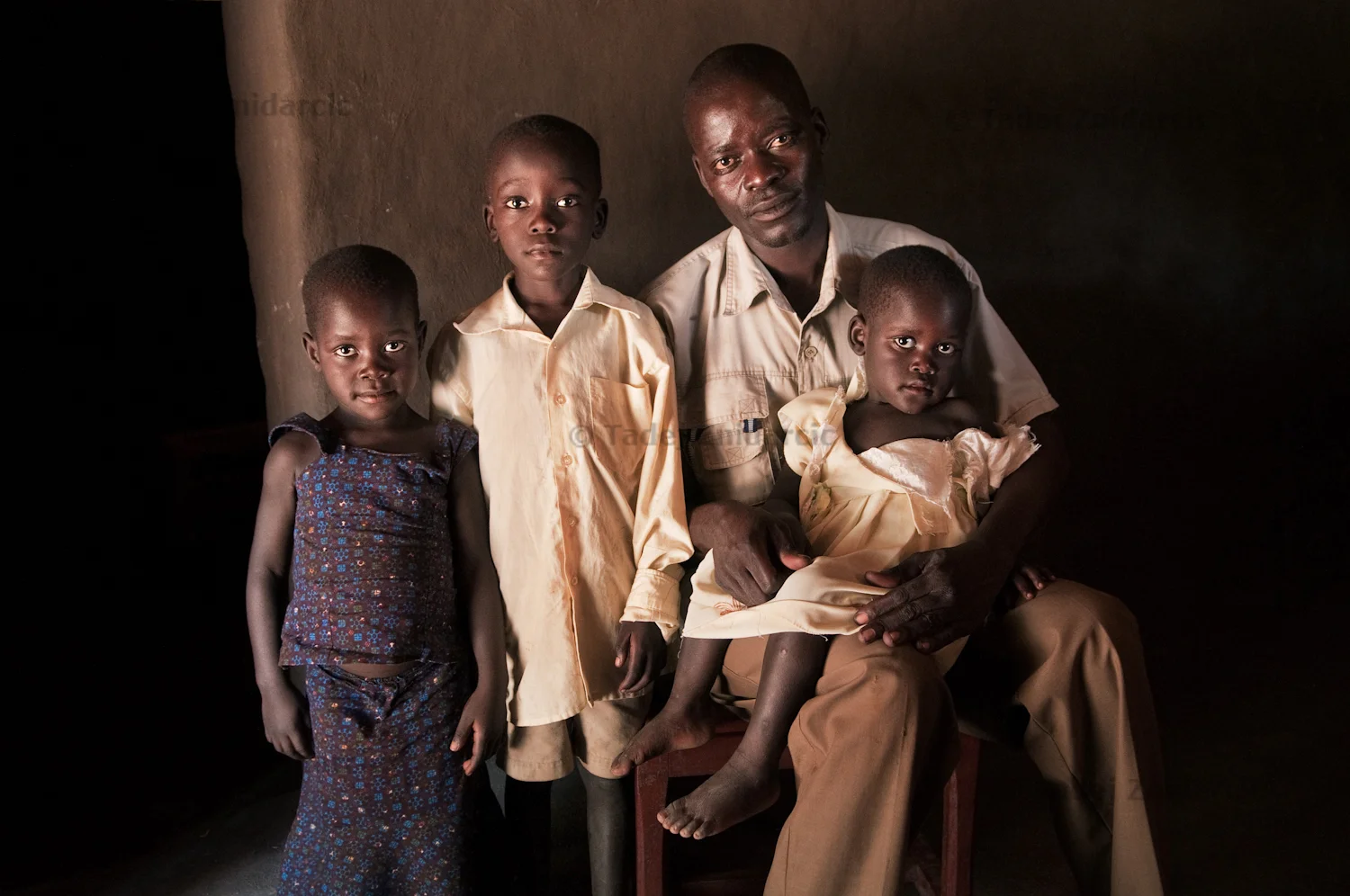 Valente Inziku with his children Patricia Alezuyo, Joshua Tabu, and Convert Diana at their home in Aribio village, Arua District. Valente Inziko's wife died during childbirth in October 2010 in Arua Hospital. 