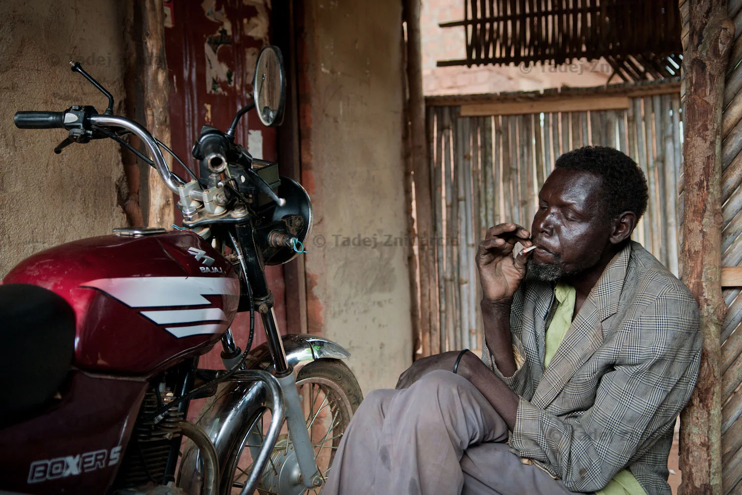 William Oryem smokes a cigarette in a shack close to his home in Kitgum Town. His son Charles was abducted by the LRA in 1992.