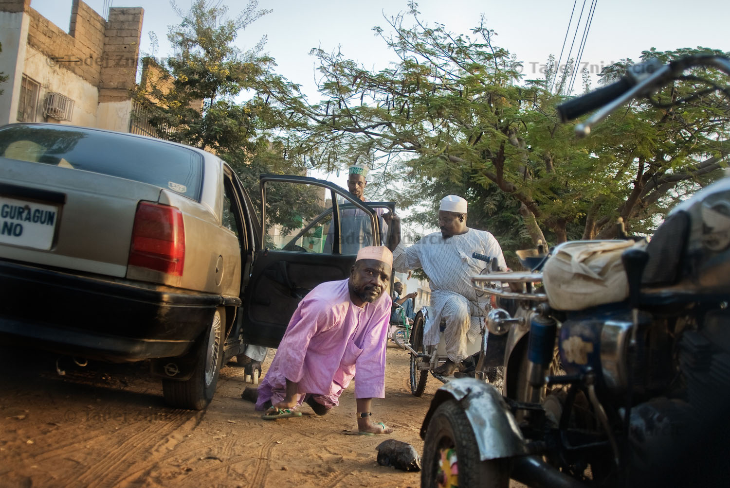 Member of KPVTA exits organization's car at the KPVTA headquarters where members meet regularly. Polio victims mostly can't walk and depending on how their limbs were affected by the disease they use different ways to move. Often they use knees and protect their hands with flip-flops.