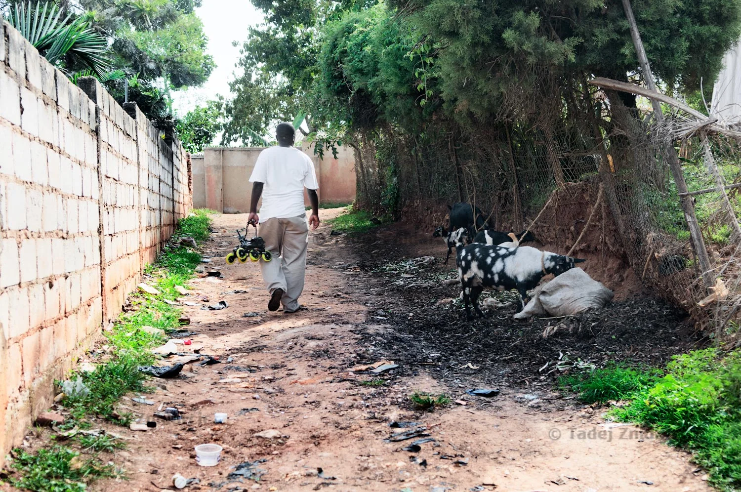 Coach Ddungu Moses carries skates on a road close to his home in Kabalagala, neighbourhood of Kampala, Uganda. Moses is a self-thought inline skating coach. Most of his knowledge comes from watching skating videos.