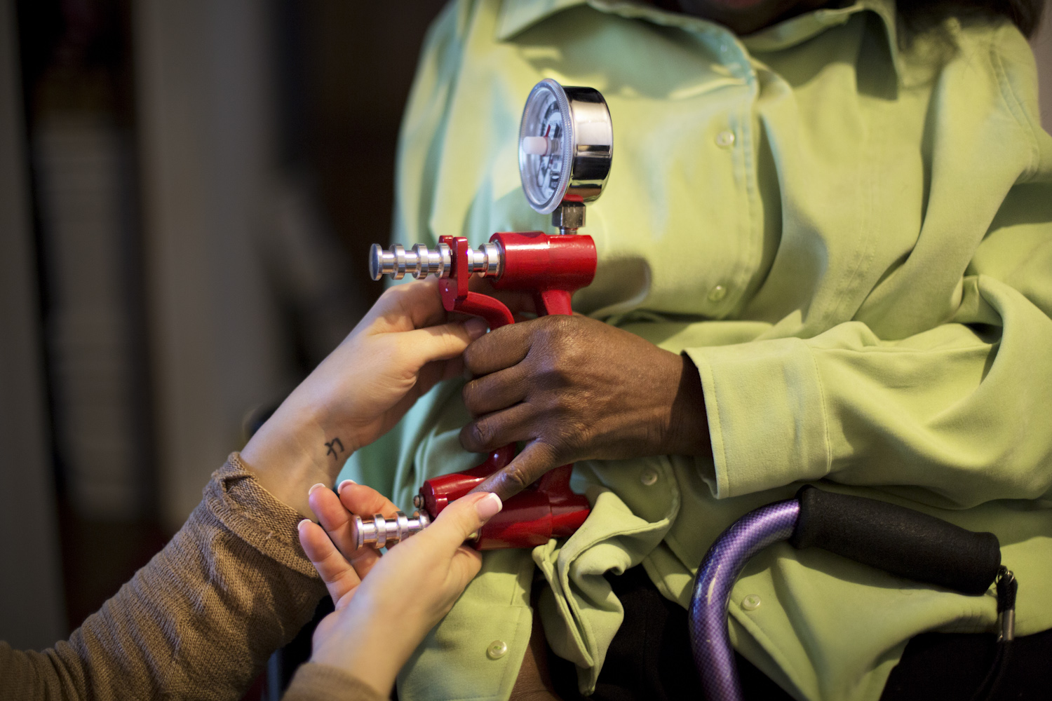 Occupational therapist Stacy measure the strength of Katy's grip.