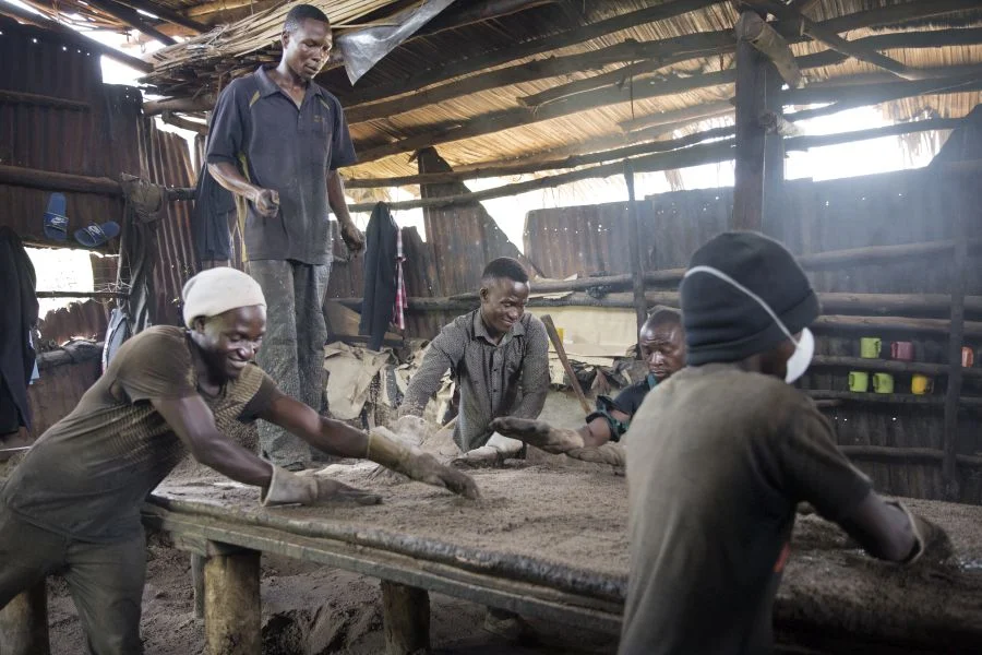 In his father's factory, Peter and other workers make tar paper used in construction.