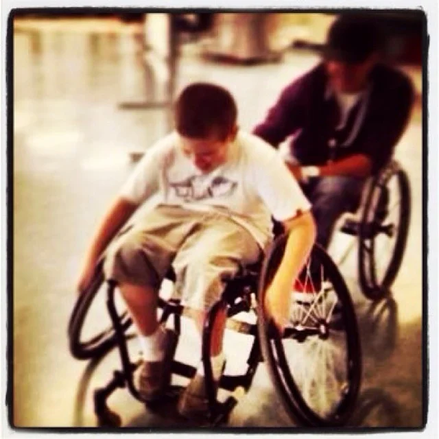 Helping a blind student feel accepted by having the same experience as his classmates, pushing my tennis wheelchair