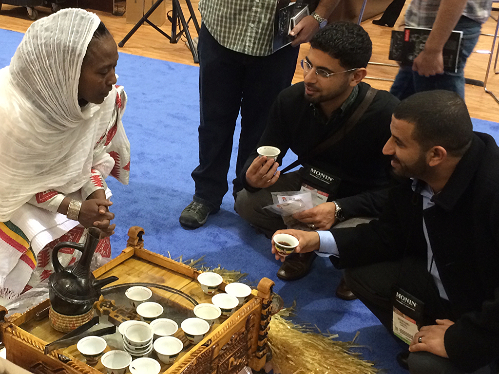Mokhtar (left) and Ibrahim (right) meet with an Ethiopian Farmer at the 2014 Speciality Coffee Association Conference 