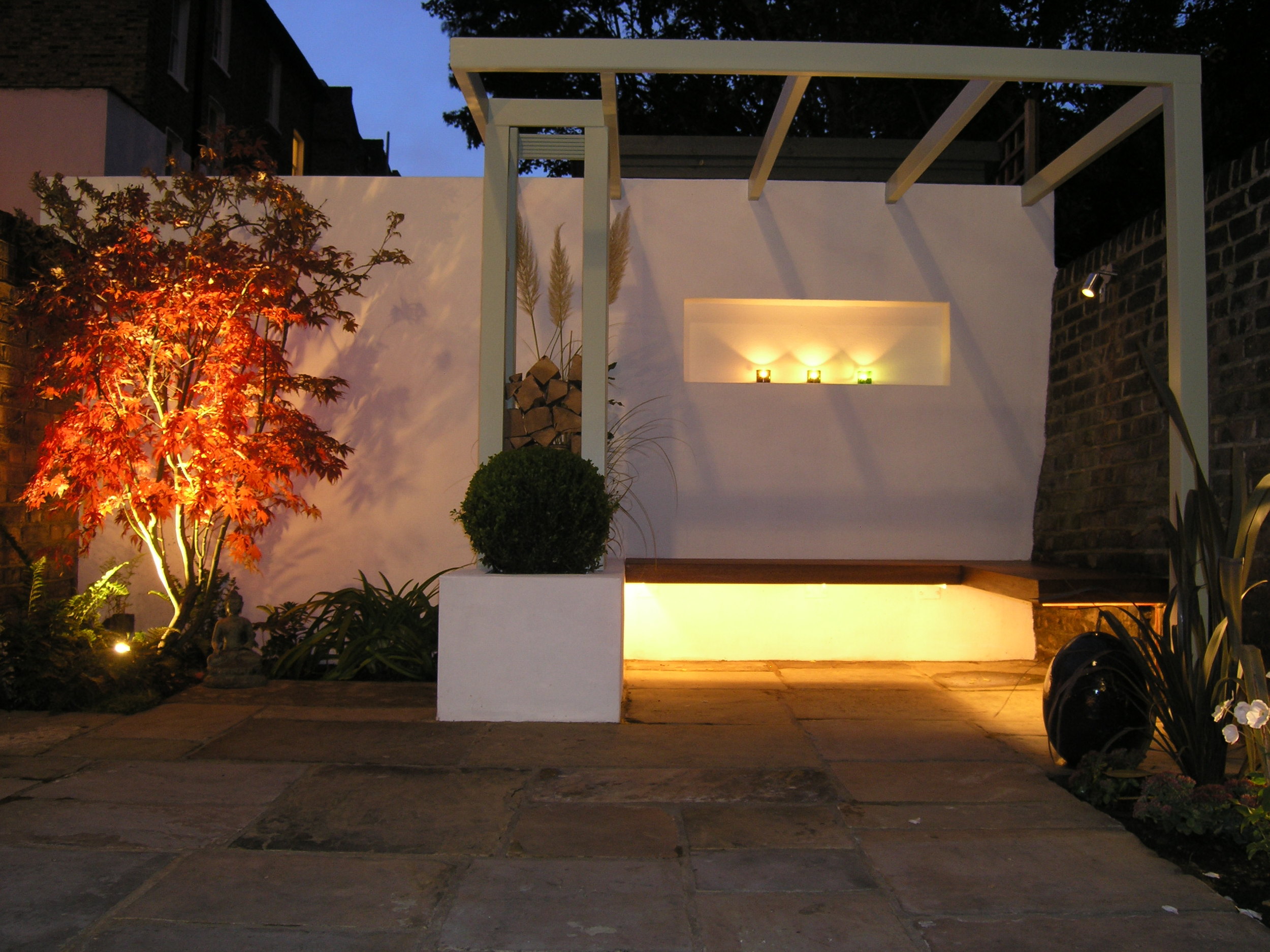 Low maintenance garden ideas UK with lighting and bespoke furniture