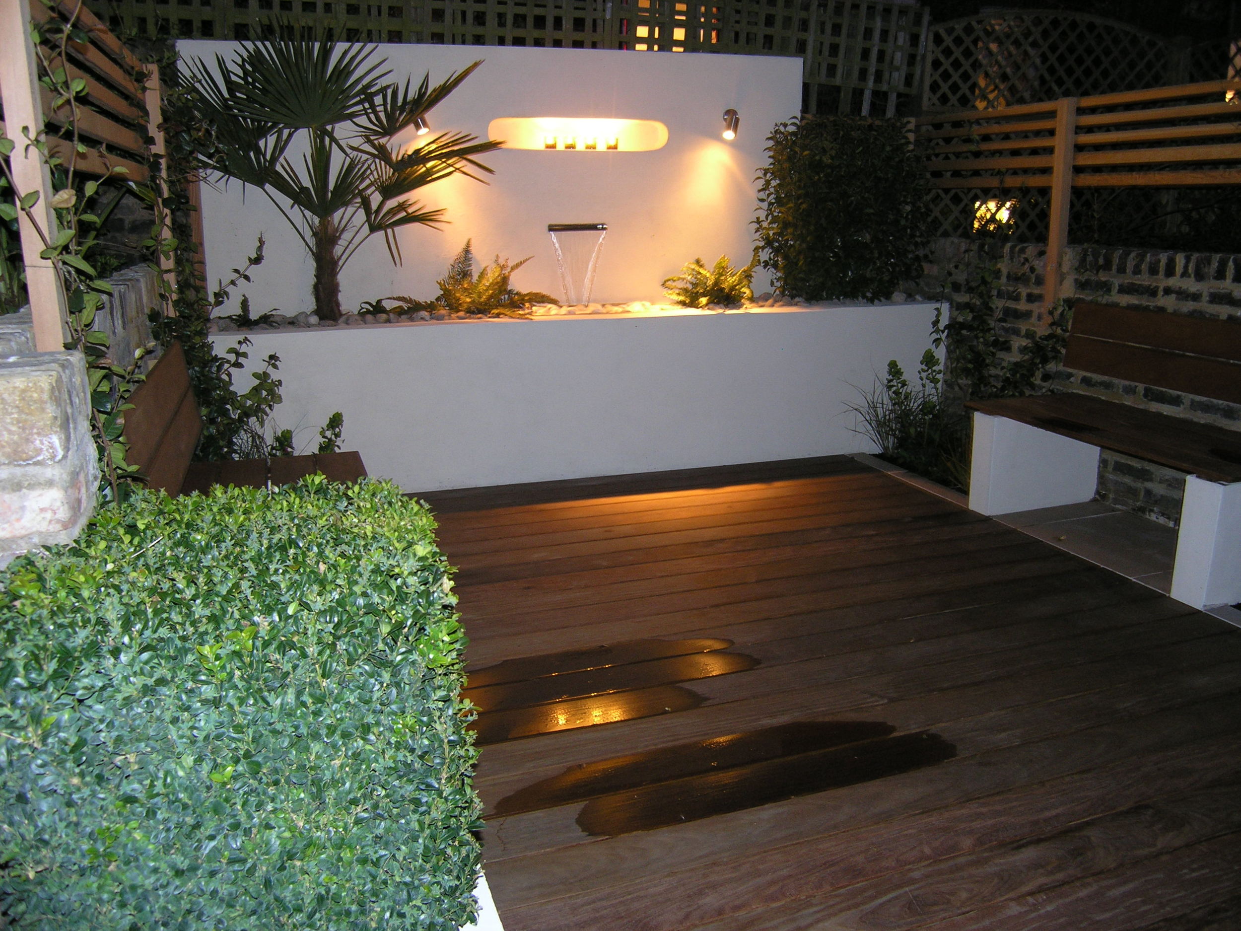 Small town garden design with hardwood decking and water feature