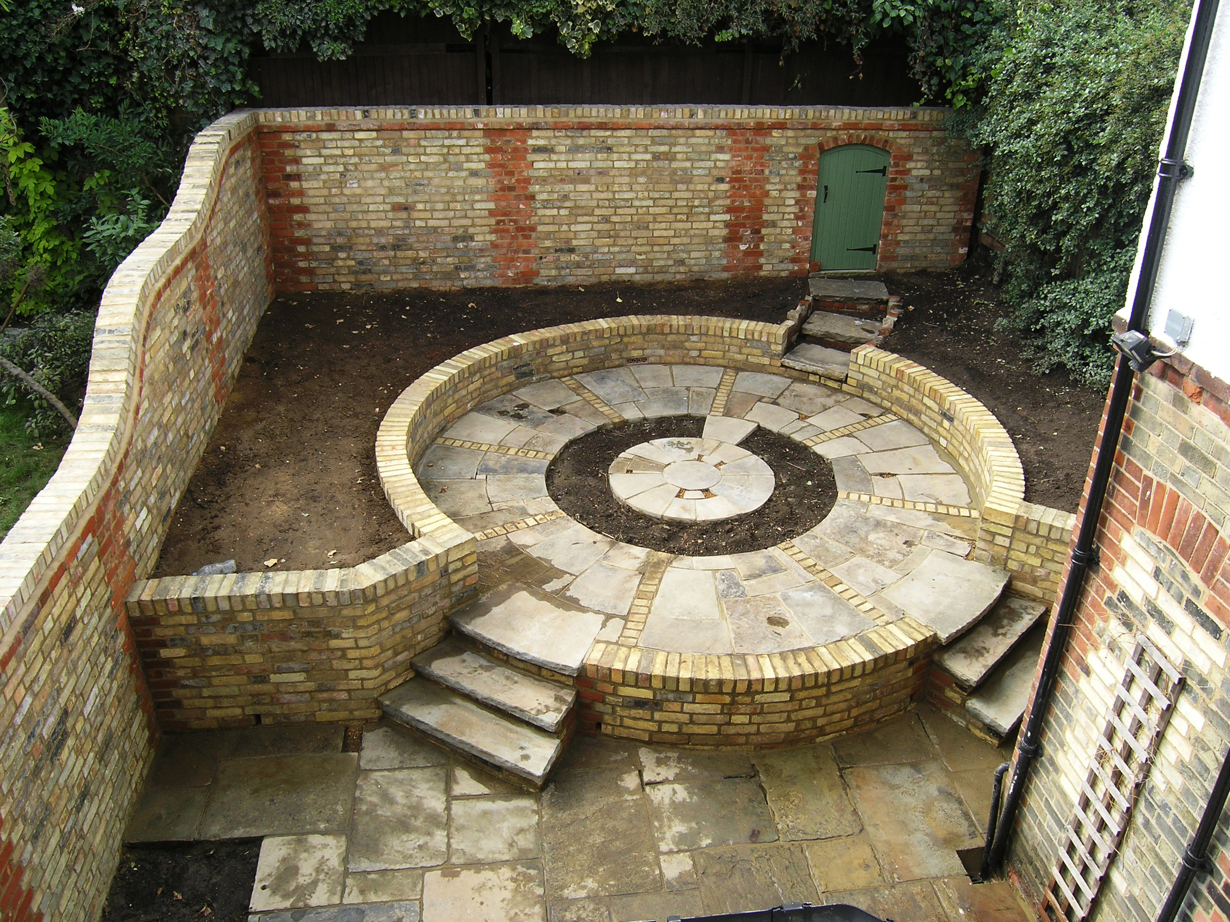 Round garden design using reclaimed bricks in North London N6