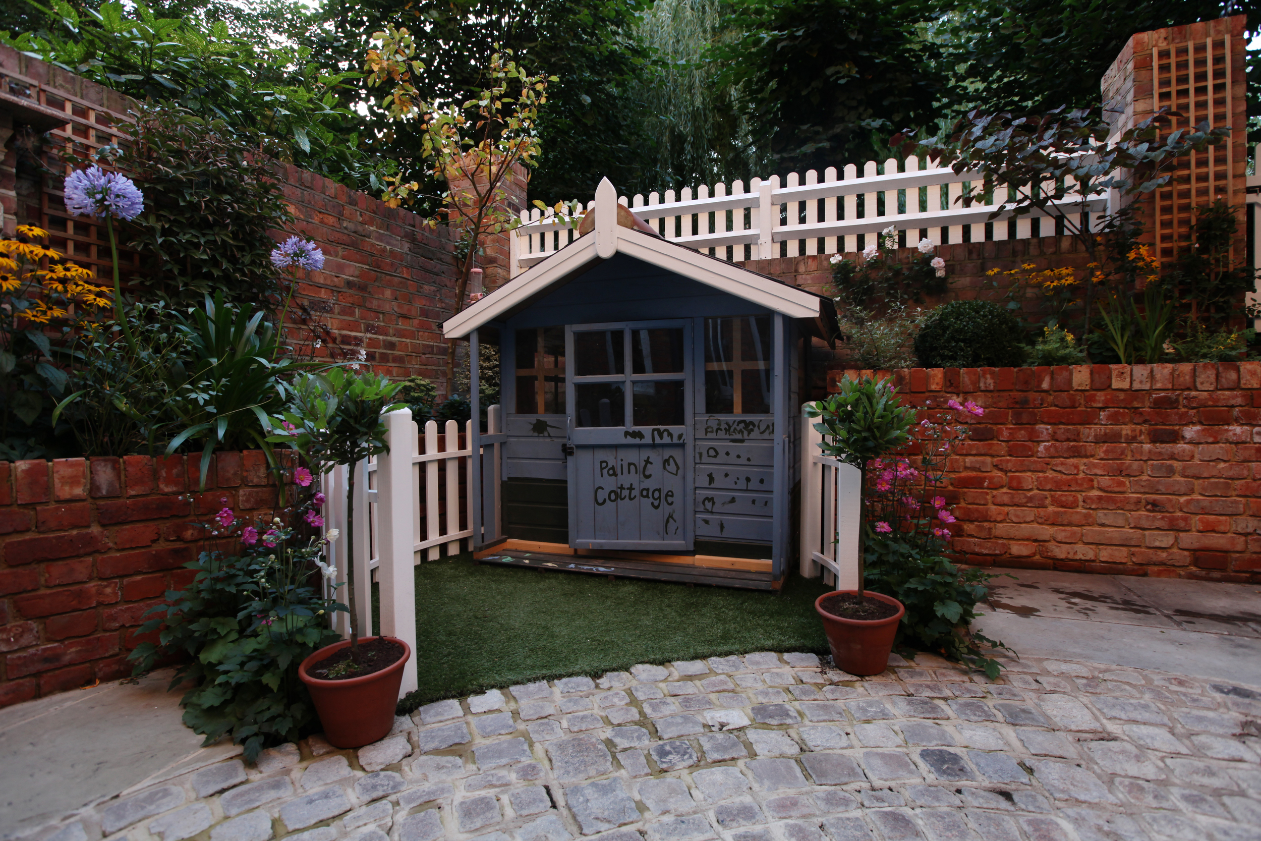 Small courtyard garden design in NW6 with play house and granite setts