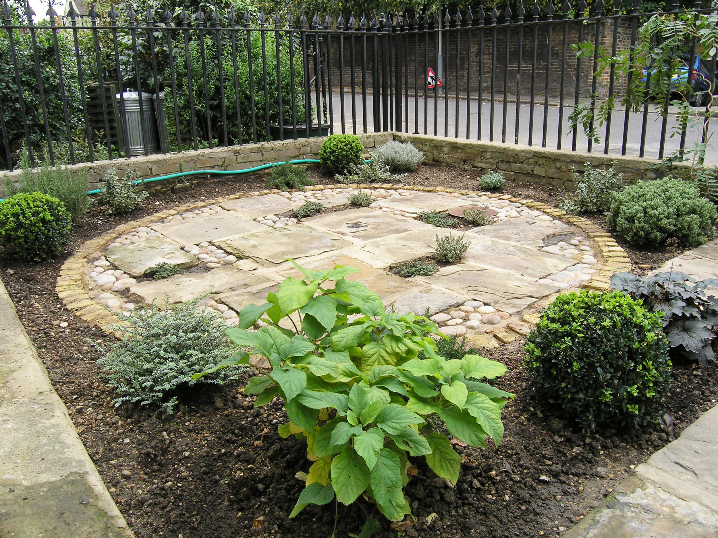 Round front garden design in Islington with traditional materials