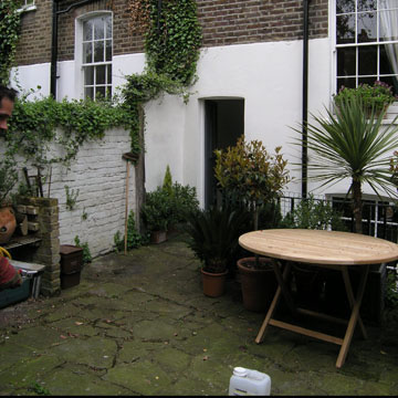 North London courtyard garden before a makeover, with a moss covered patio