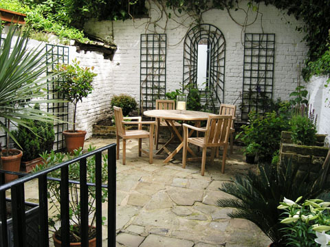 After a garden makeover this courtyard looks brighter with mirrors and a clean patio