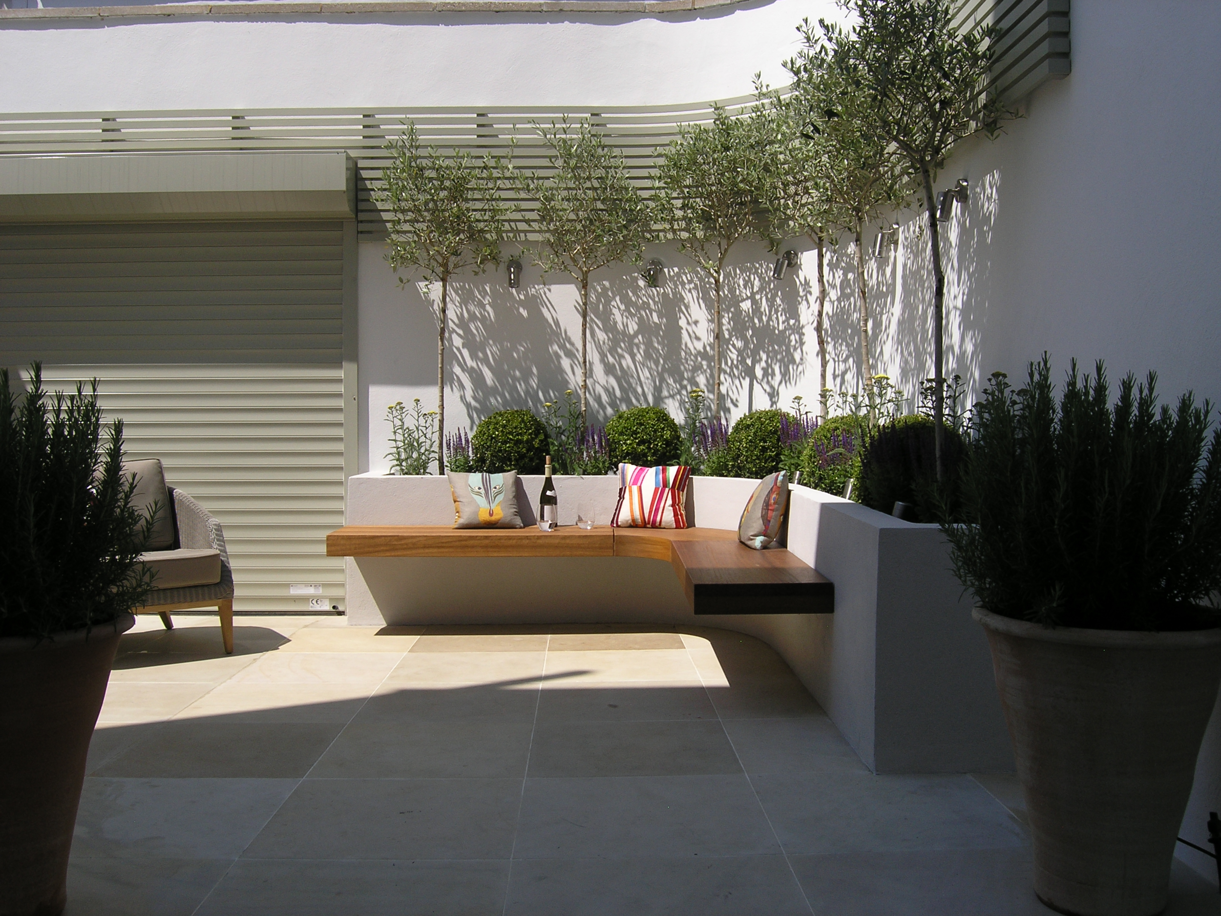 Small courtyard garden design in West London with benches and patio