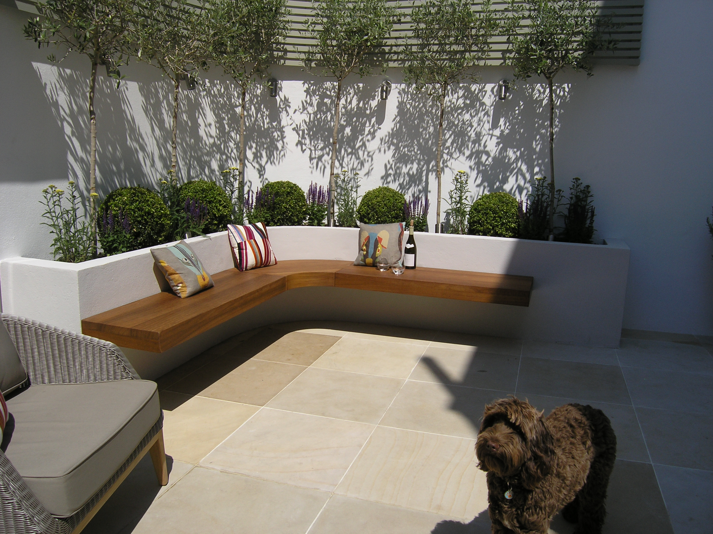 Courtyard garden ideas in London N8 with patio, benches and low maintenance planting