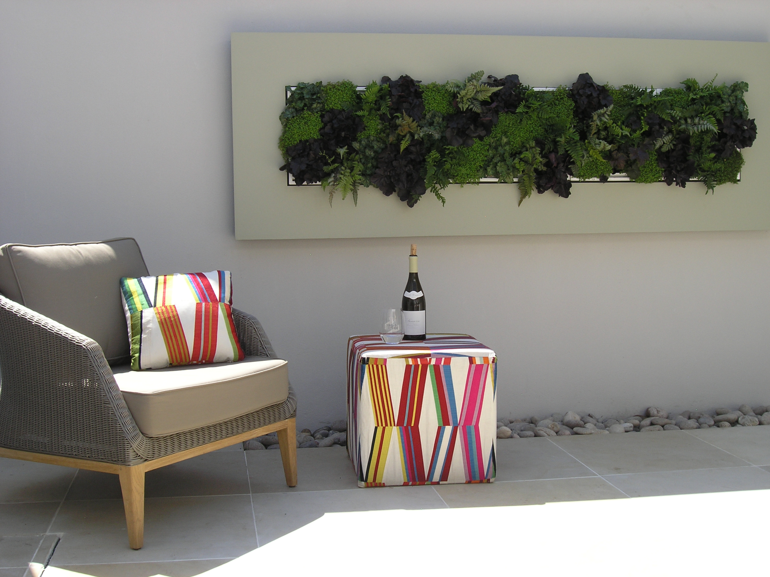  Courtyard ideas by London landscapers with colourful outdoor furniture and plants set into the wall. 
