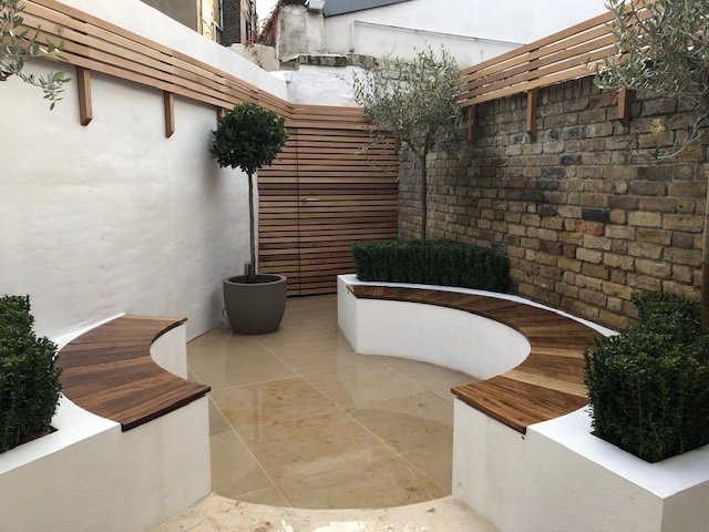 Small courtyard garden in North London designed with circular patio and benches