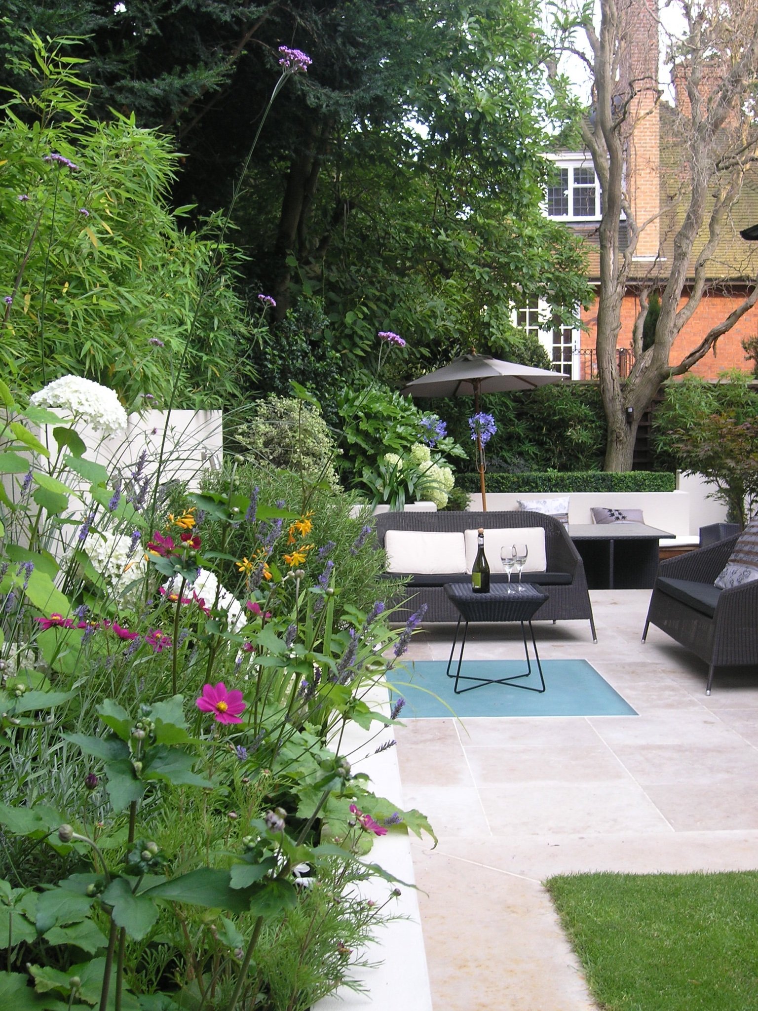 Modern garden landscaping in North London with patio, lawn and seating area